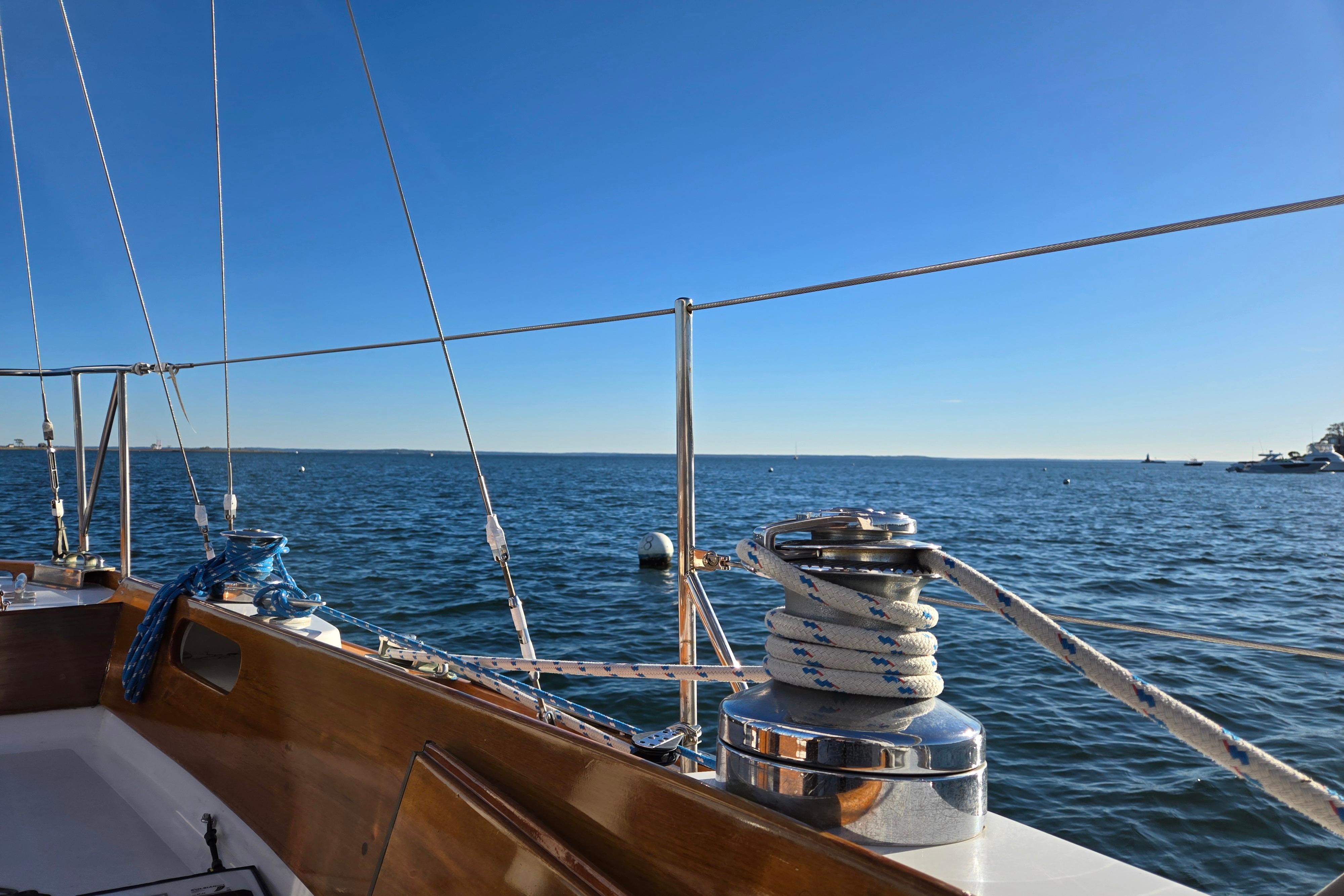 Hinckley Bermuda 40 sailboat deck view, 1970 model, overlooking calm blue ocean under clear sky.
