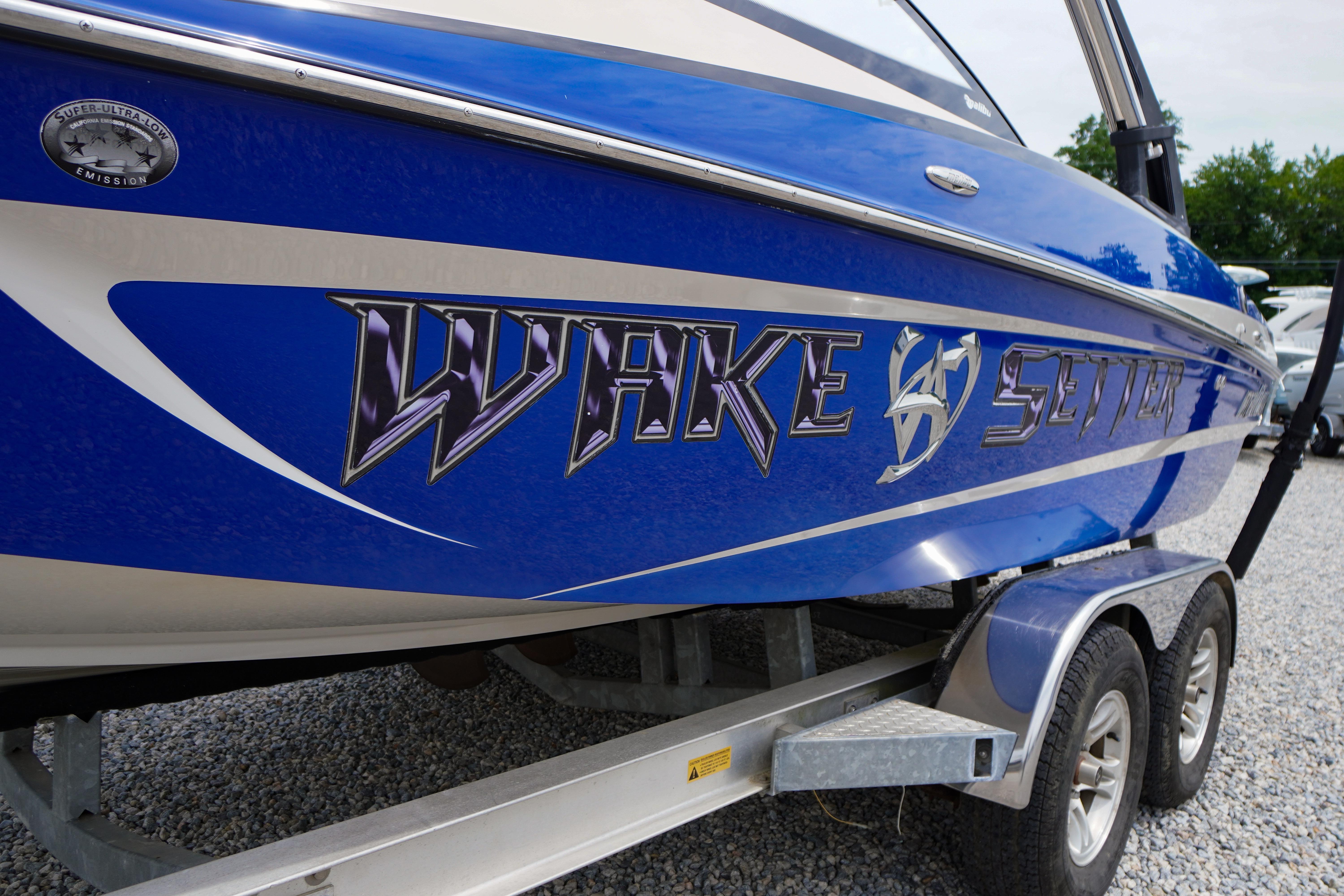 Blue 2011 Malibu Wakesetter 21 VLX boat on trailer, side view.
