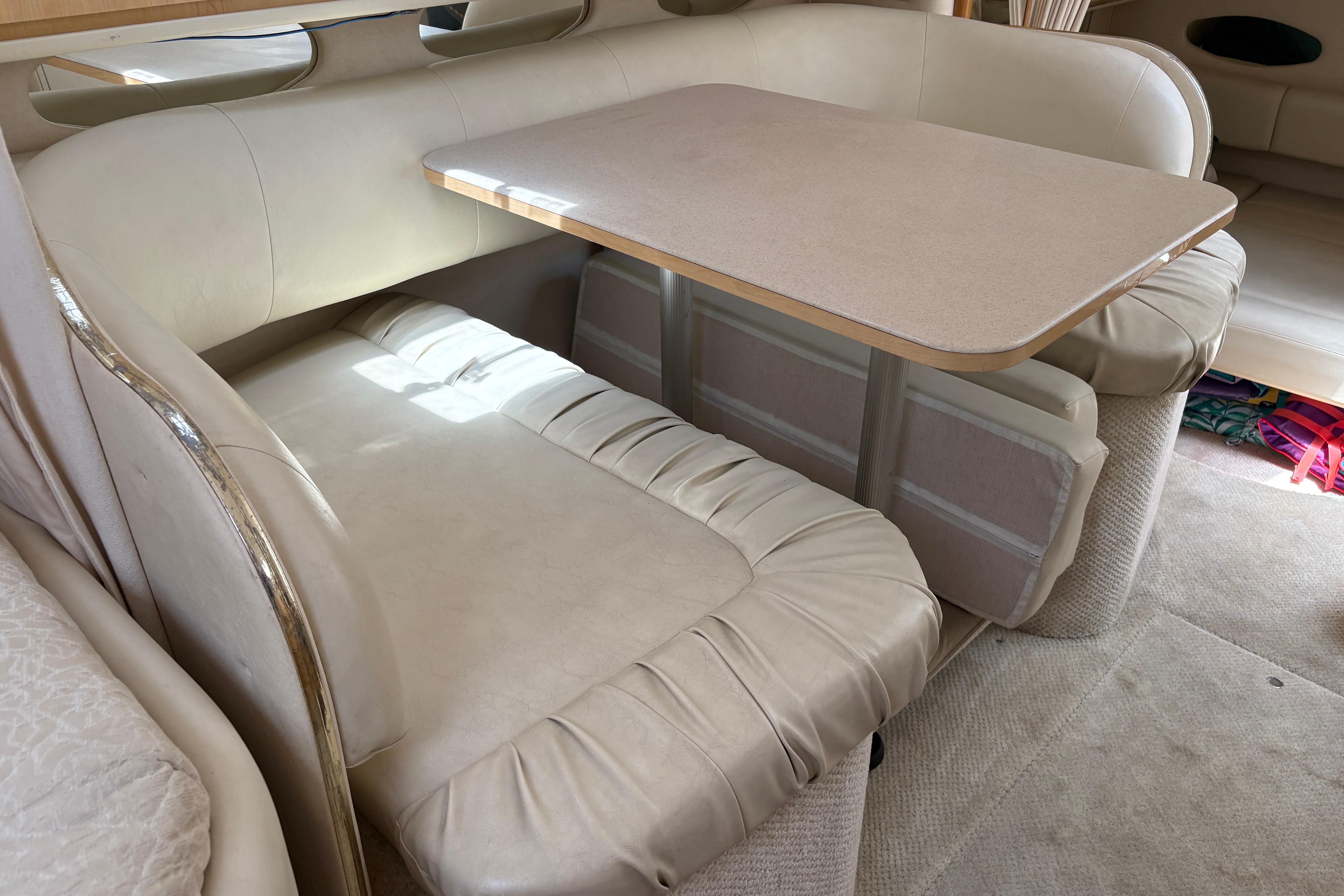 Interior of 2001 Sea Ray Sundancer 310 with beige leather seating and dining table.