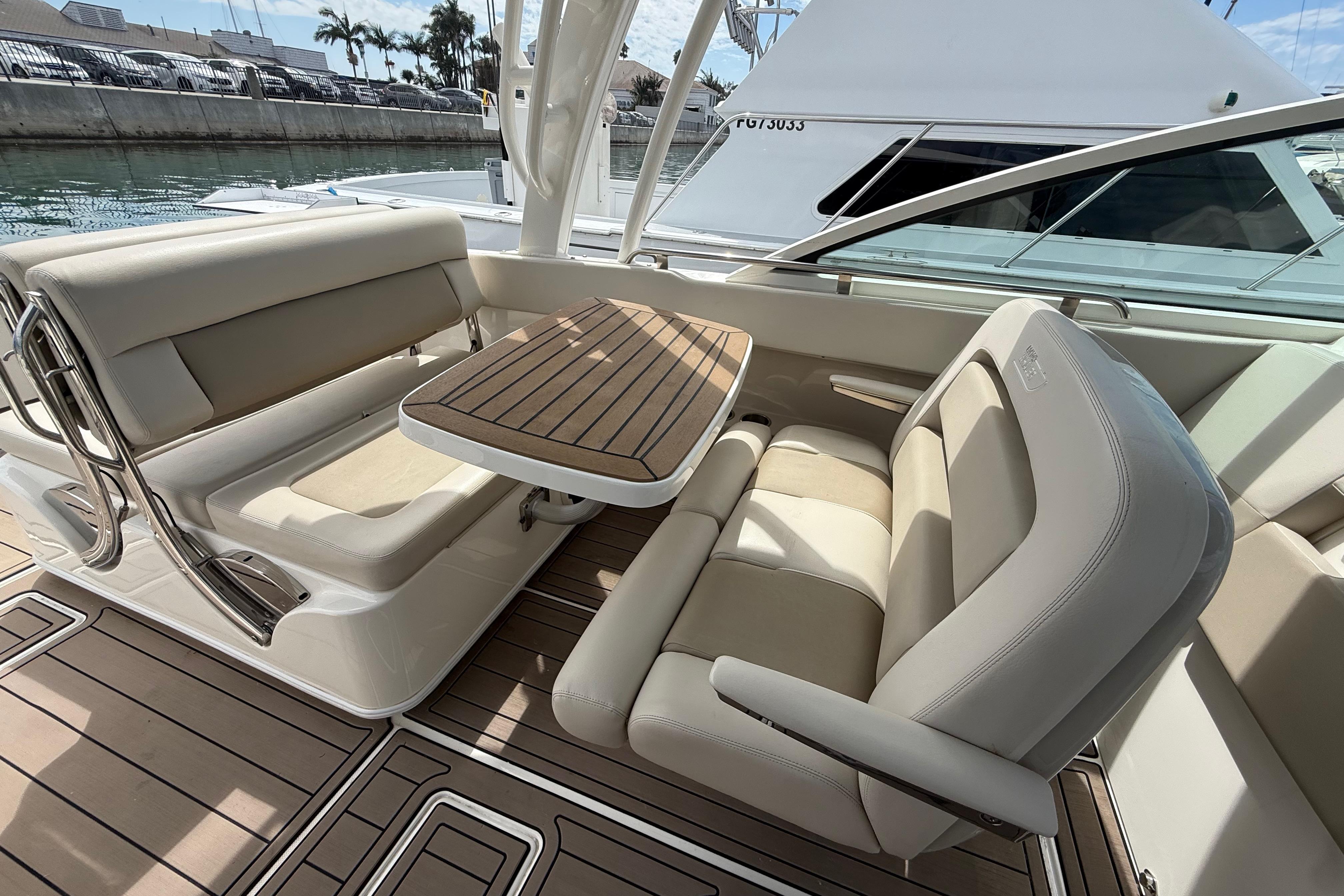2023 Boston Whaler 320 Vantage interior with beige seating and wooden table.