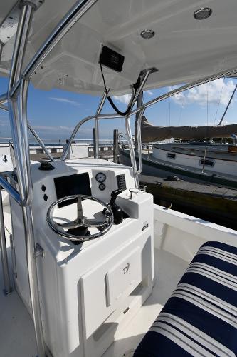 2021 Eastern 248 Center Console boat interior with steering wheel and striped seating.