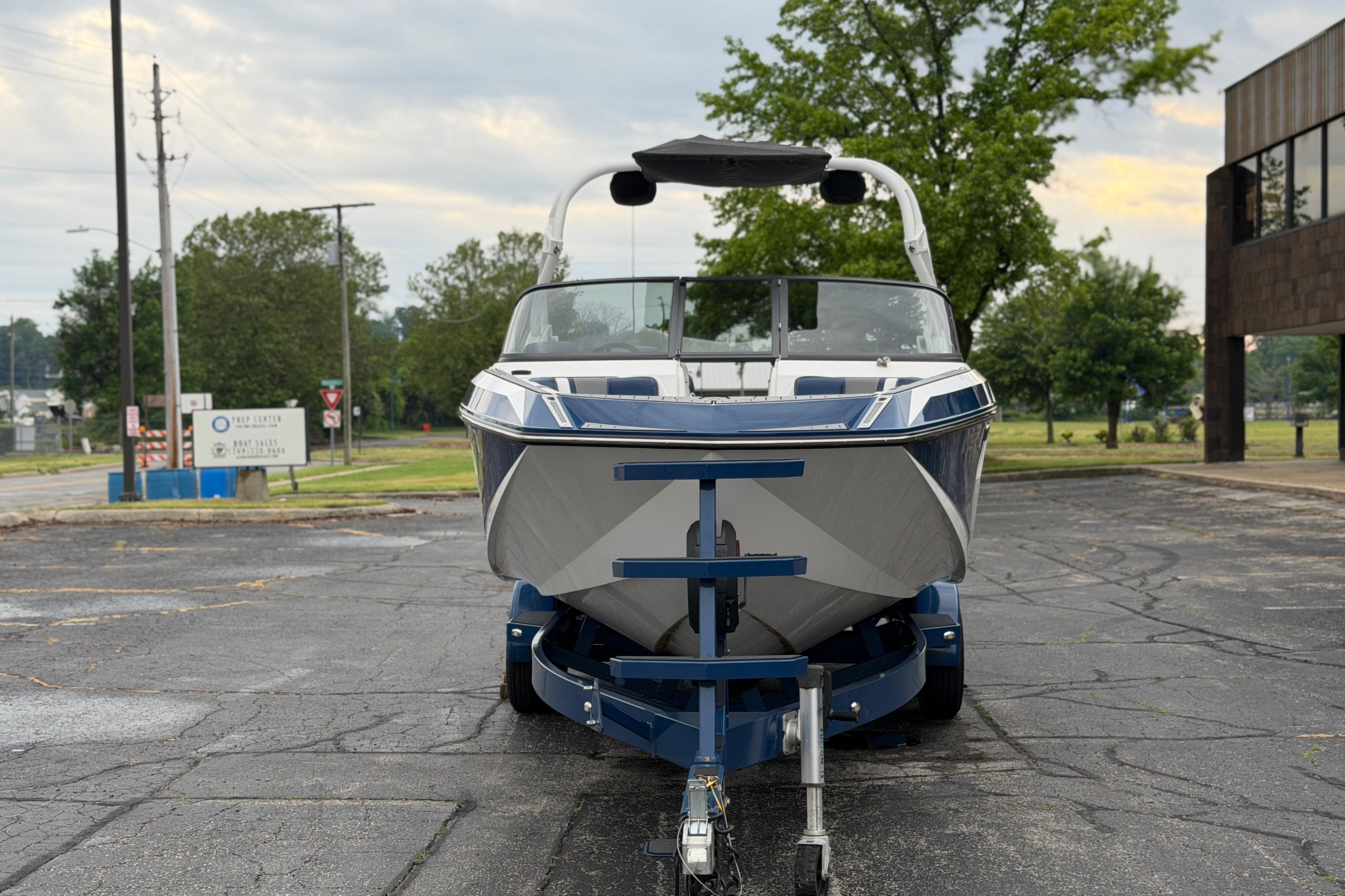 2016 Naitique G25 boat on trailer in parking lot, overcast sky.