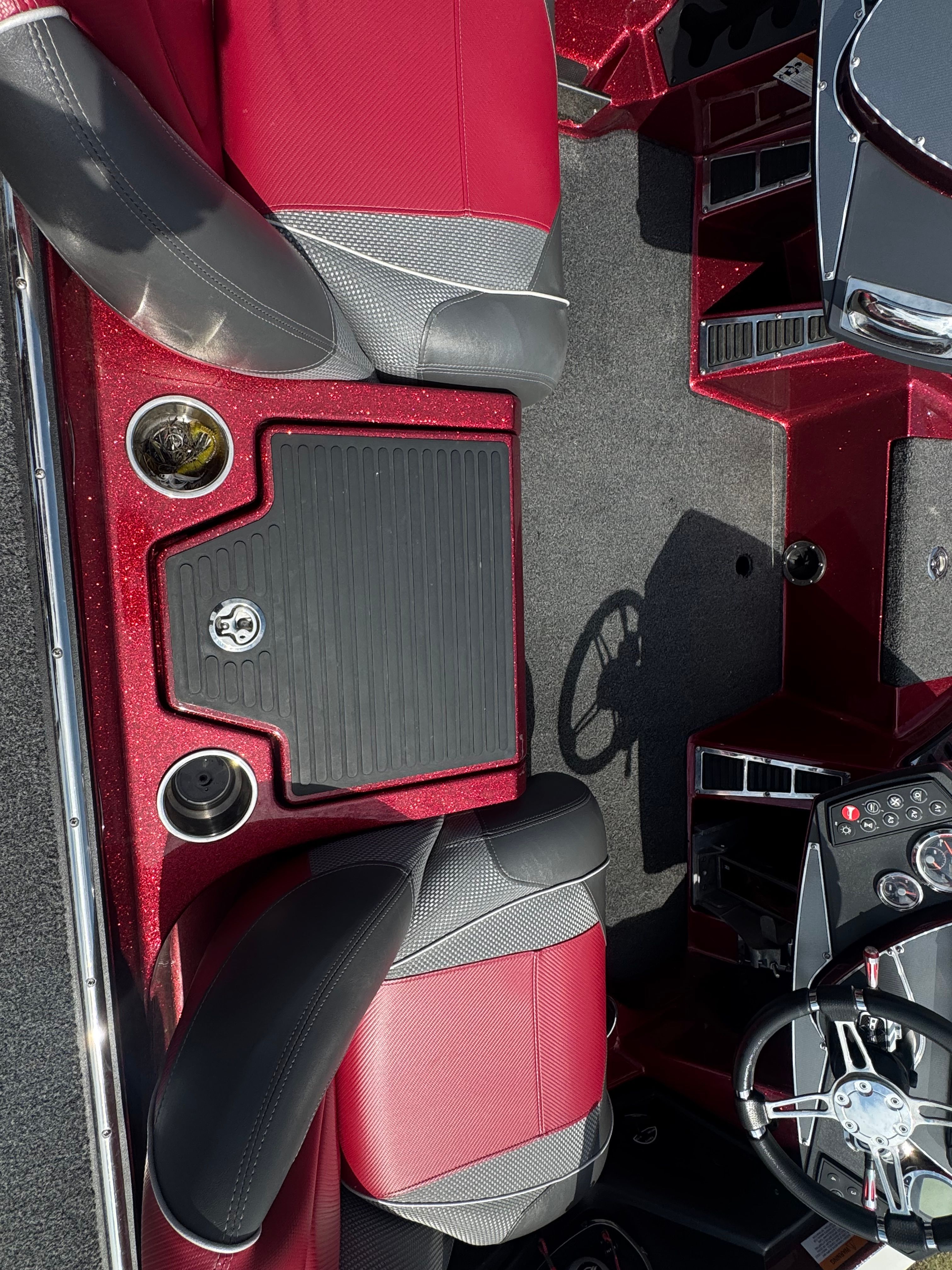 Interior view of a Ranger 521C boat with red and gray seats and a steering console.