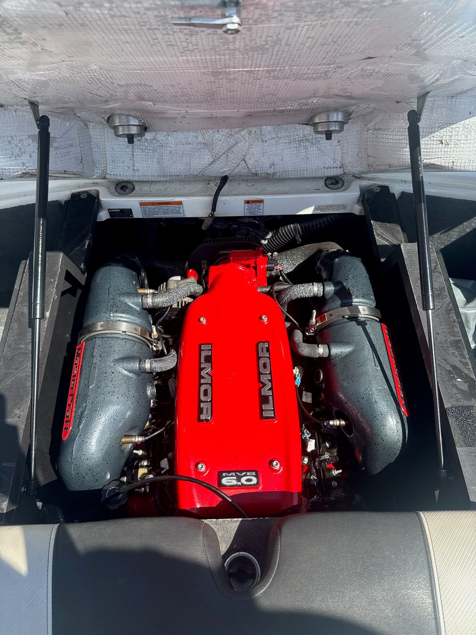 The engine compartment of a 2013 MasterCraft X-25 features a red Ilmor engine.