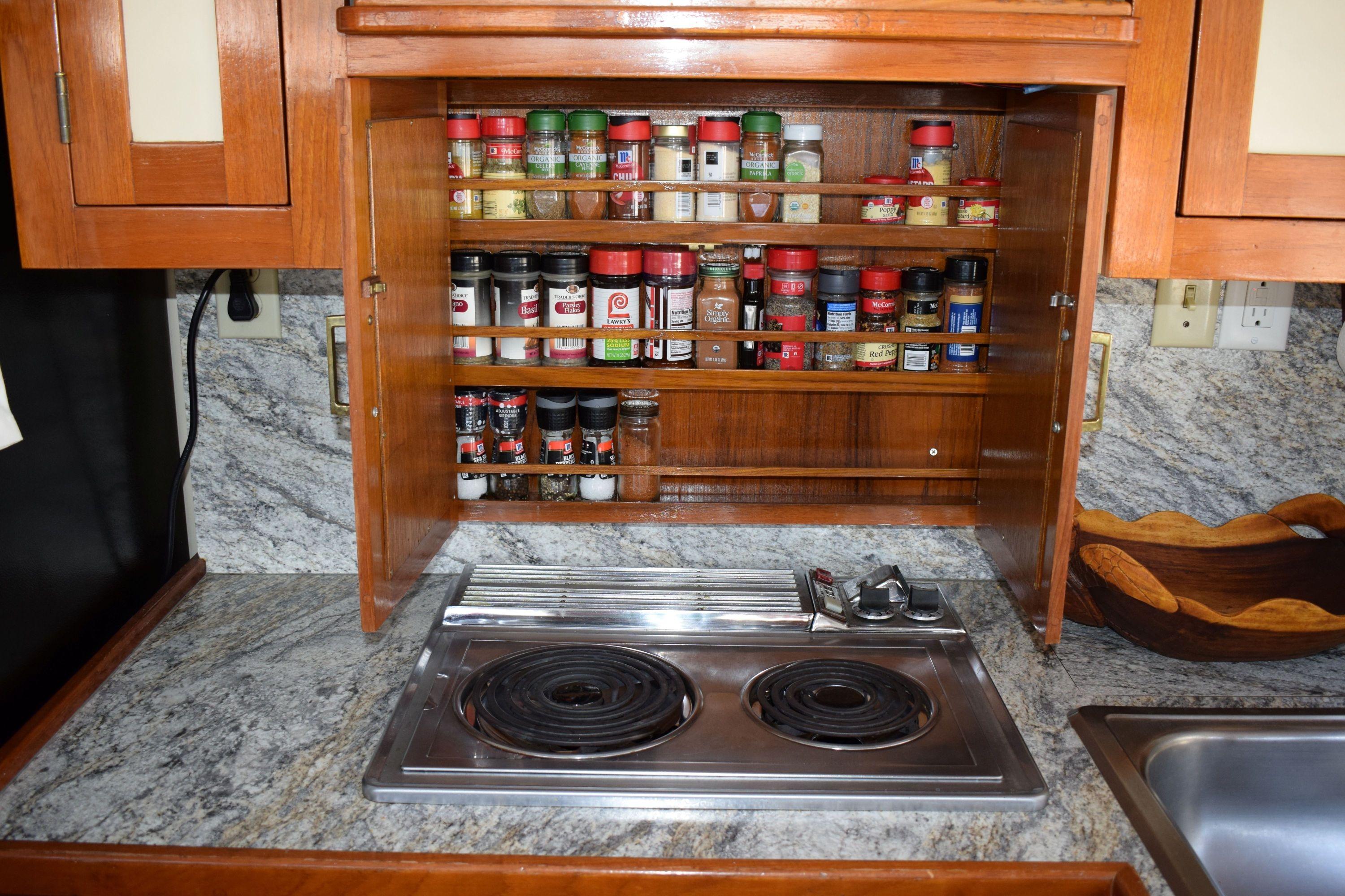 Galley kitchen in 1980 Cheoy Lee 52 Motorsailer with spice rack and electric stove.