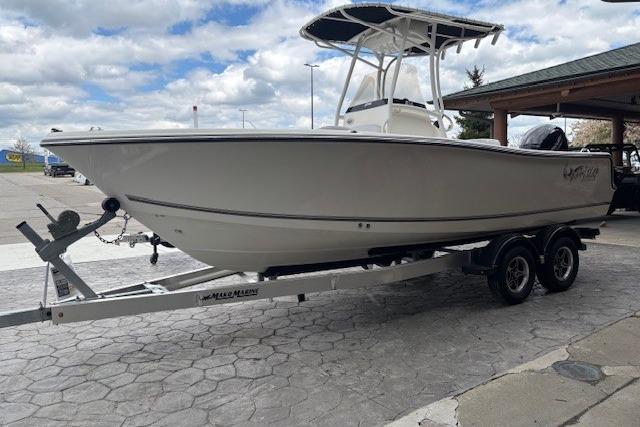 2026 Mako 214 Center Console boat on trailer, parked outdoors under cloudy sky.