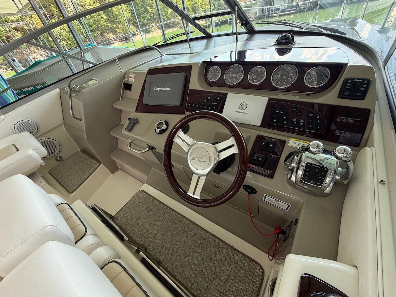 The cockpit of a 2011 Sea Ray Sundancer 370 with modern instruments and a sleek steering wheel.