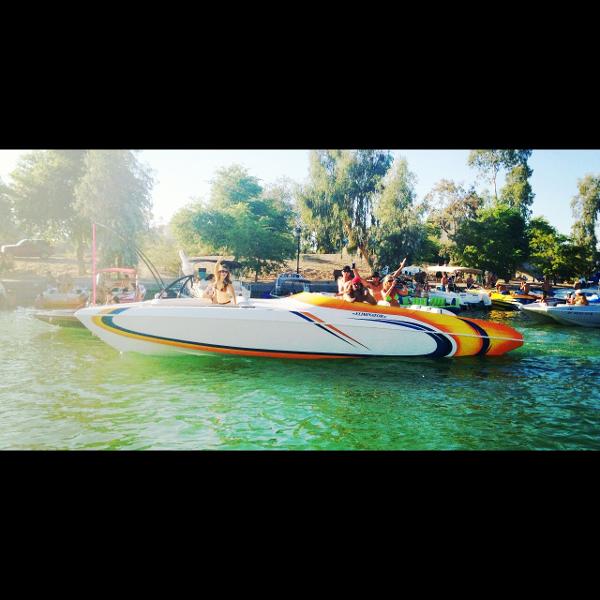 2001 Eliminator Eagle boat on a sunny lake with people onboard.