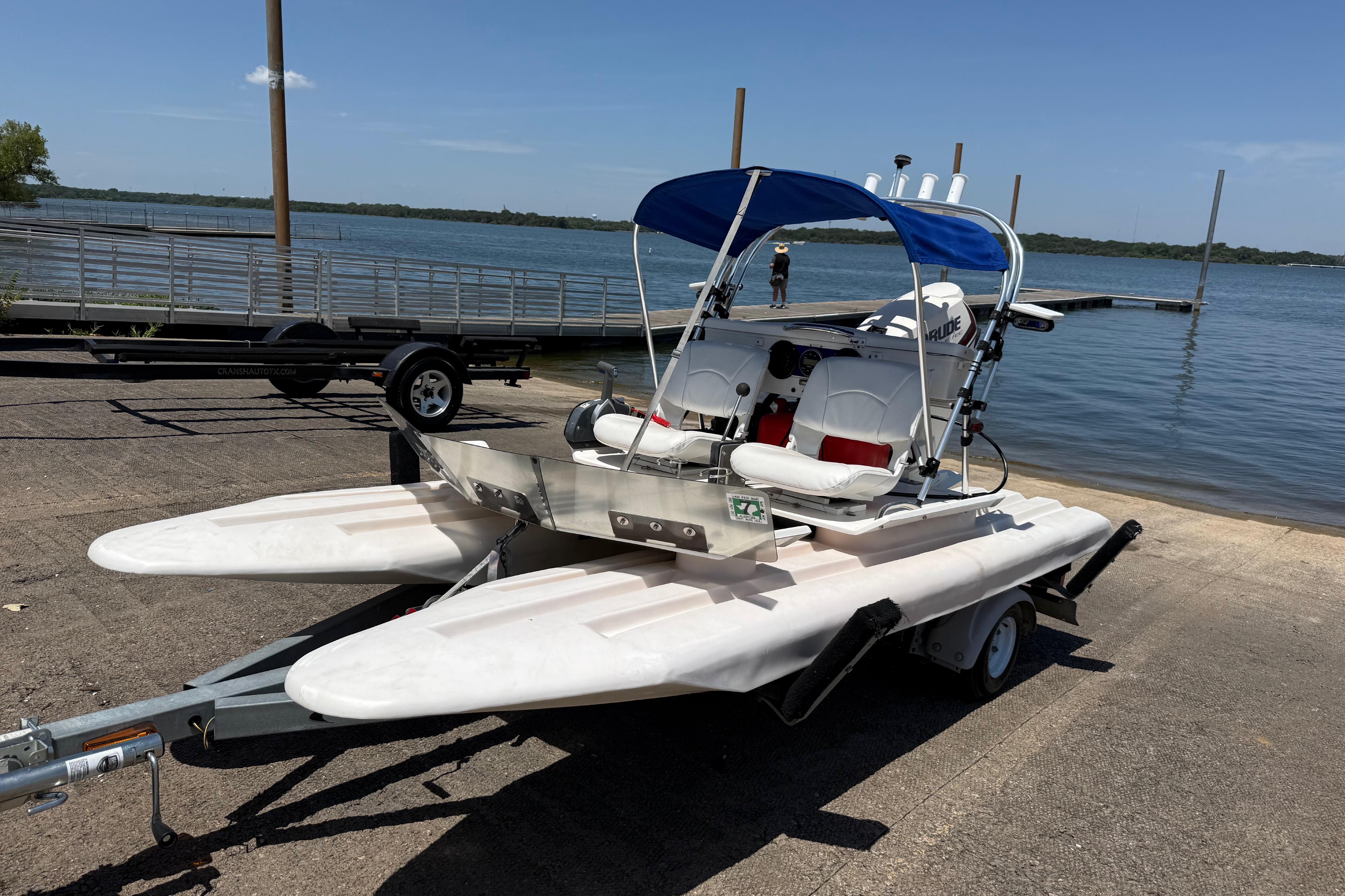 2016 CraigCat E2 Elite on trailer by lakeside, featuring dual seats and blue canopy.