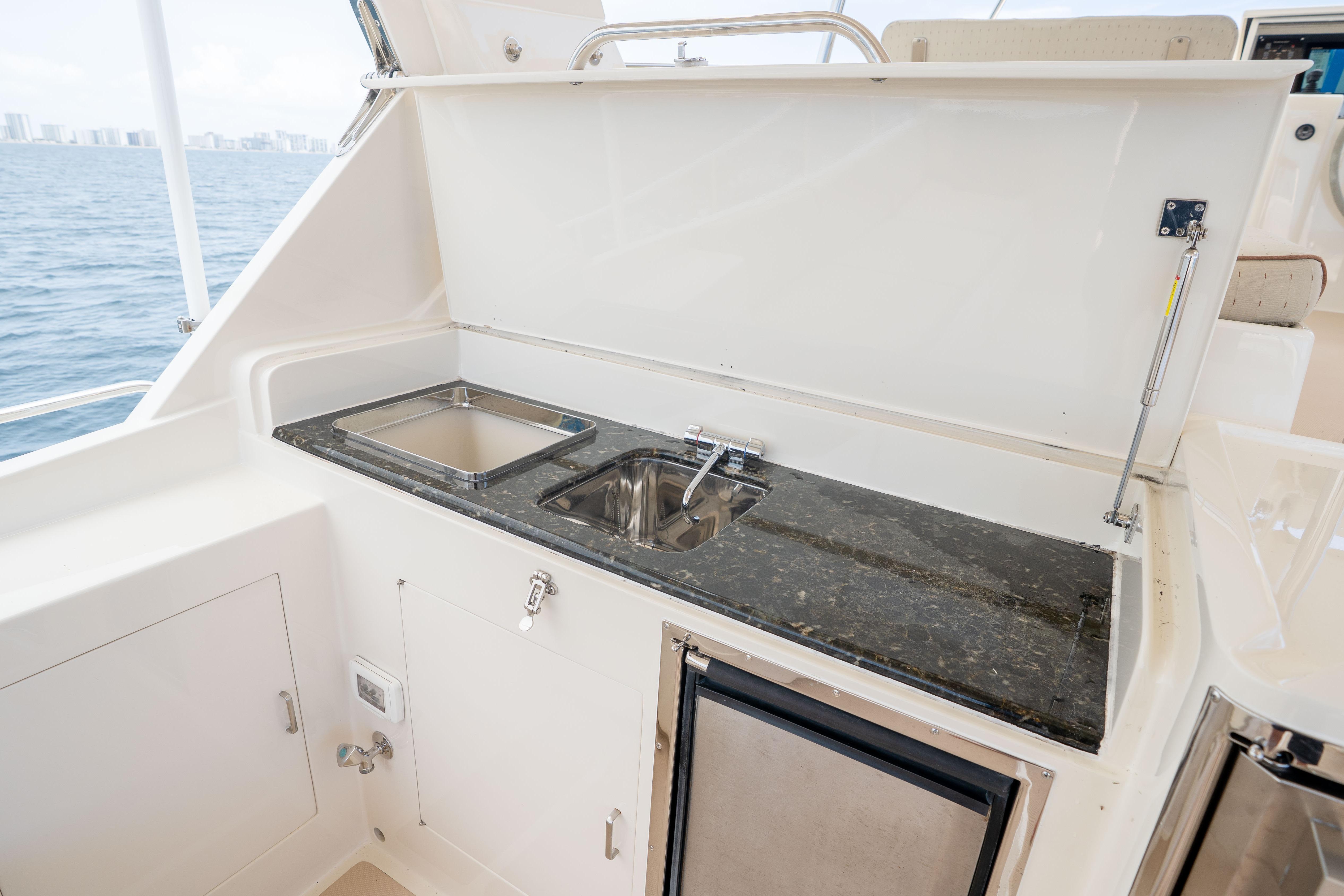 Outdoor kitchenette on a 2006 Fleming 75 yacht with sink and countertop.