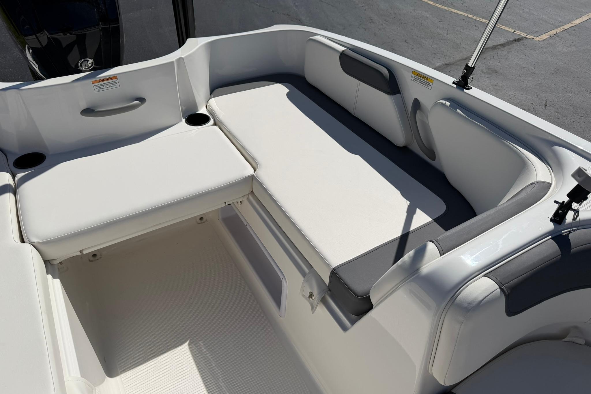 2026 Bayliner Element E18 boat interior with white cushioned seating and cup holders.