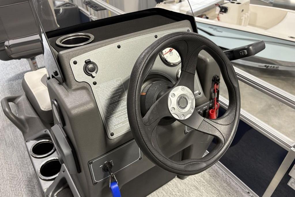 Steering console of 2026 Sun Tracker Bass Buggy 18 DLX pontoon boat, featuring cup holders.