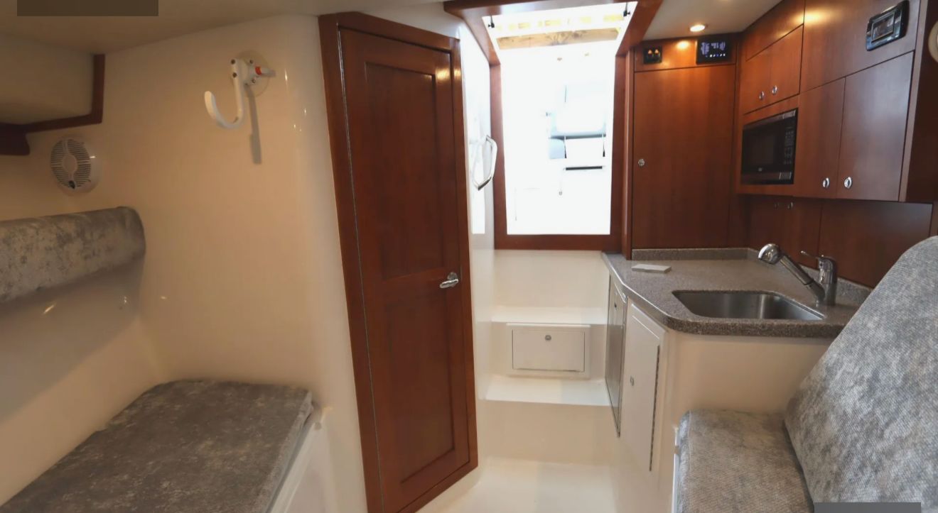 Interior of the 2024 Albemarle 30 Express with a kitchenette and seating area.