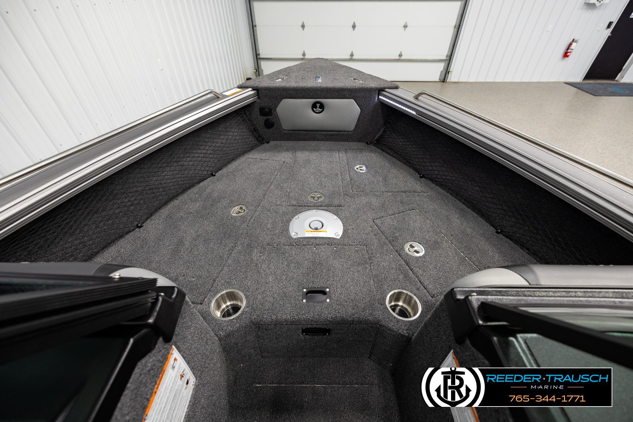 Interior view of a 2026 Lund 1975 Tyee boat, featuring carpeted flooring and cup holders.