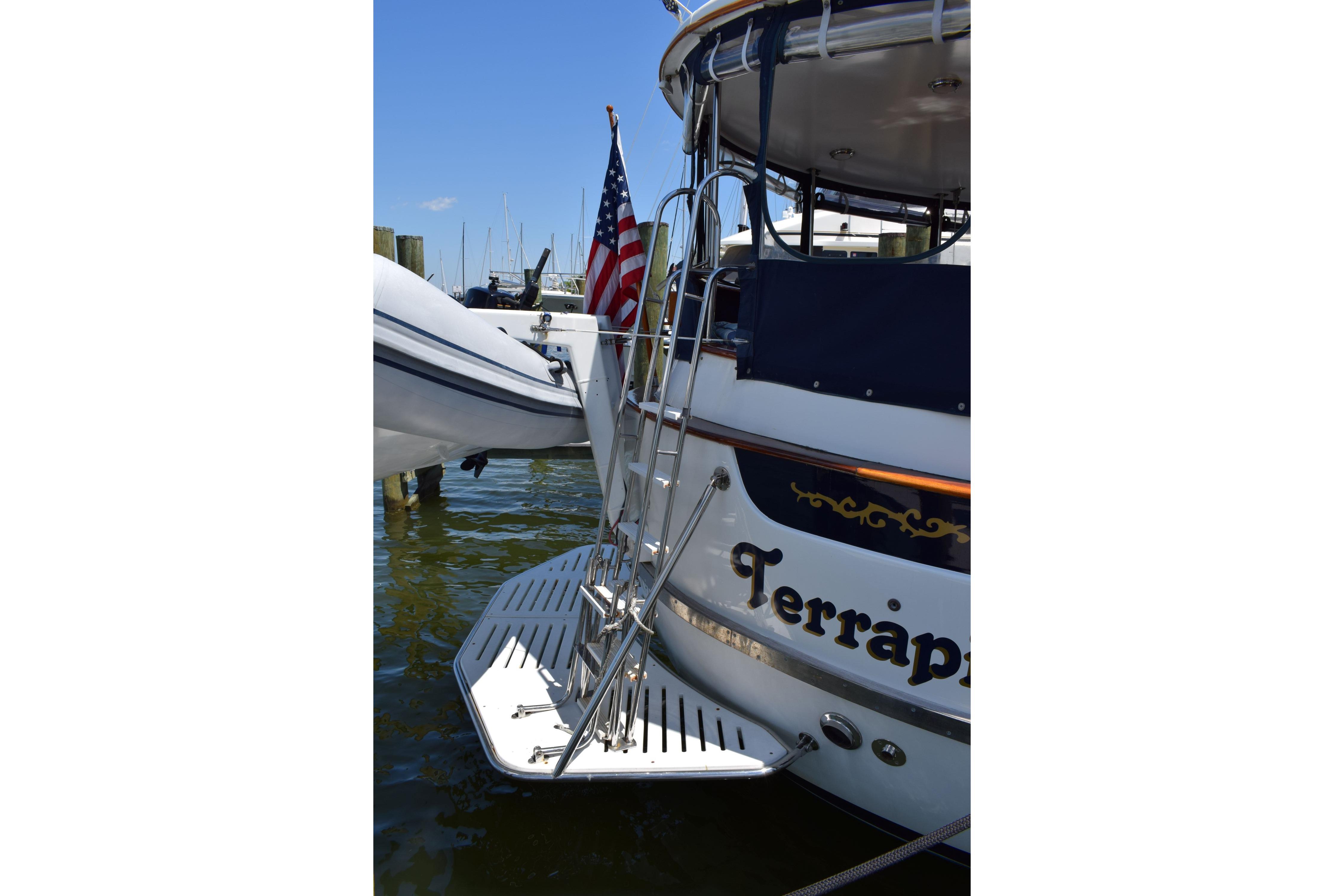 1980 Cheoy Lee 52 Motorsailer with American flag and swim platform at dock.