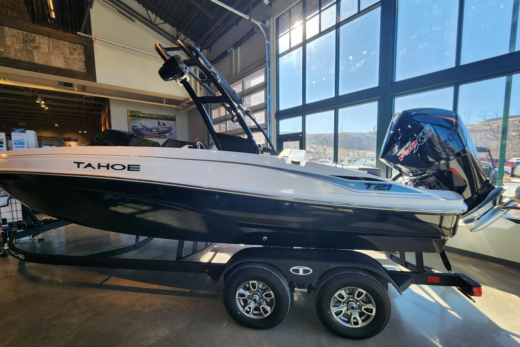 2026 Tahoe T21 boat displayed indoors with a powerful outboard motor.
