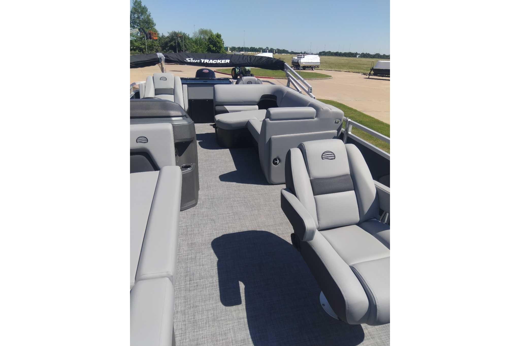 2026 Sun Tracker SportFish 20 DLX pontoon boat interior with gray seating and open deck.