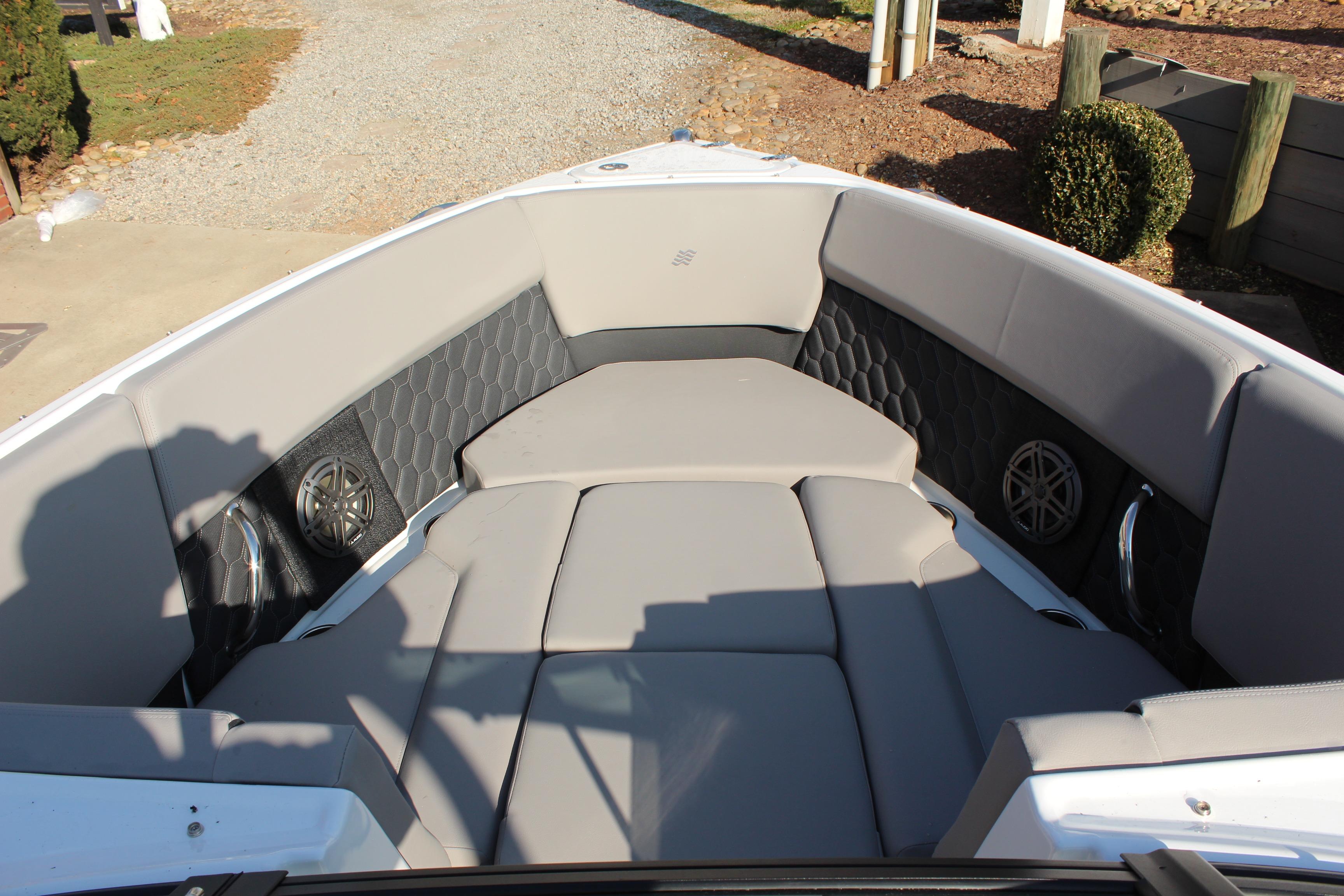 2026 Four Winns H4 boat interior with gray cushioned seating and built-in speakers.