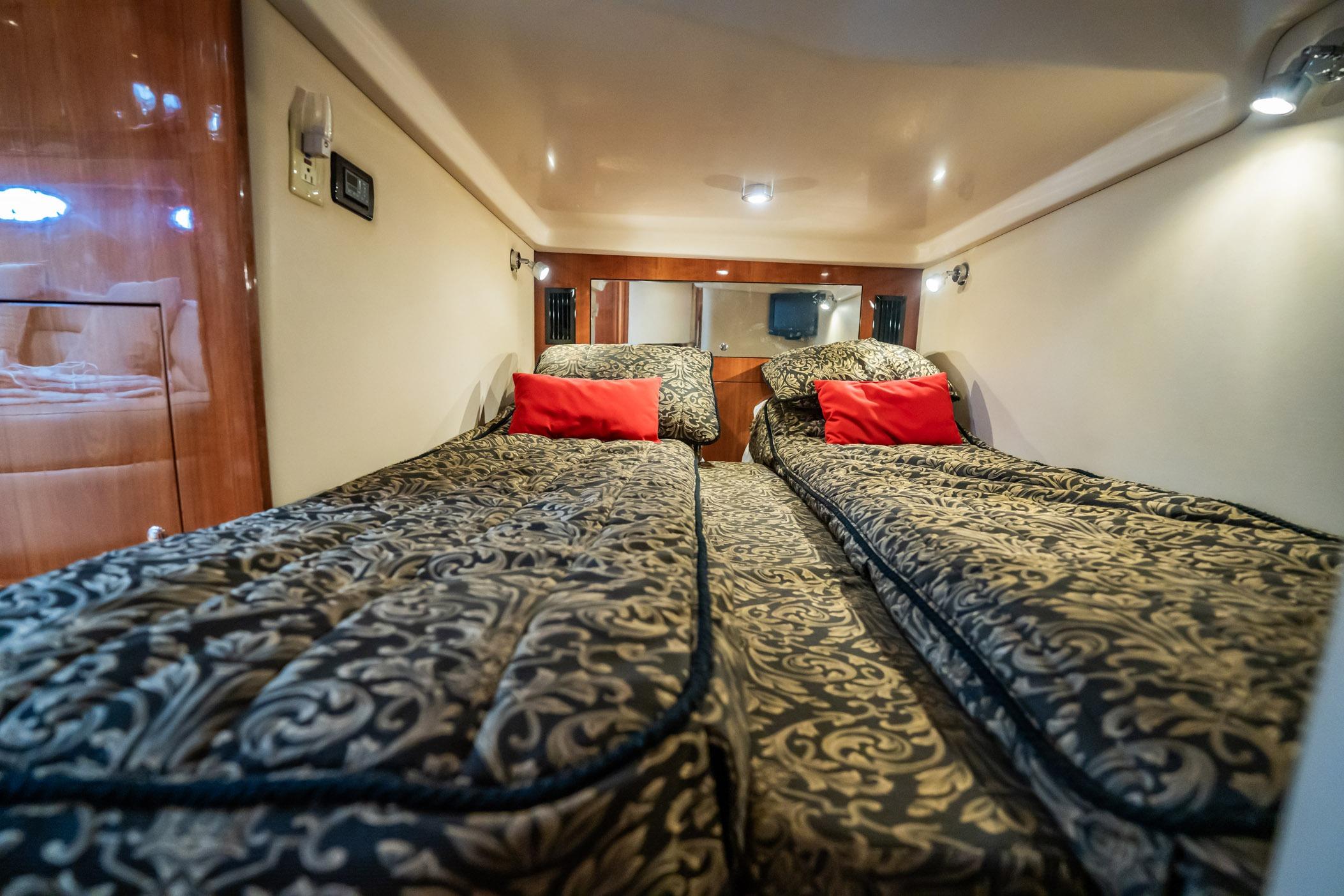 Luxurious twin cabin in 2008 Regal Commodore 4460 yacht with elegant bedding.