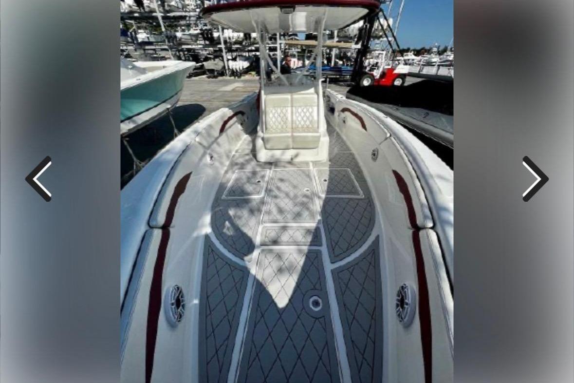 2015 Deep Impact 33 boat deck with red accents at a marina.