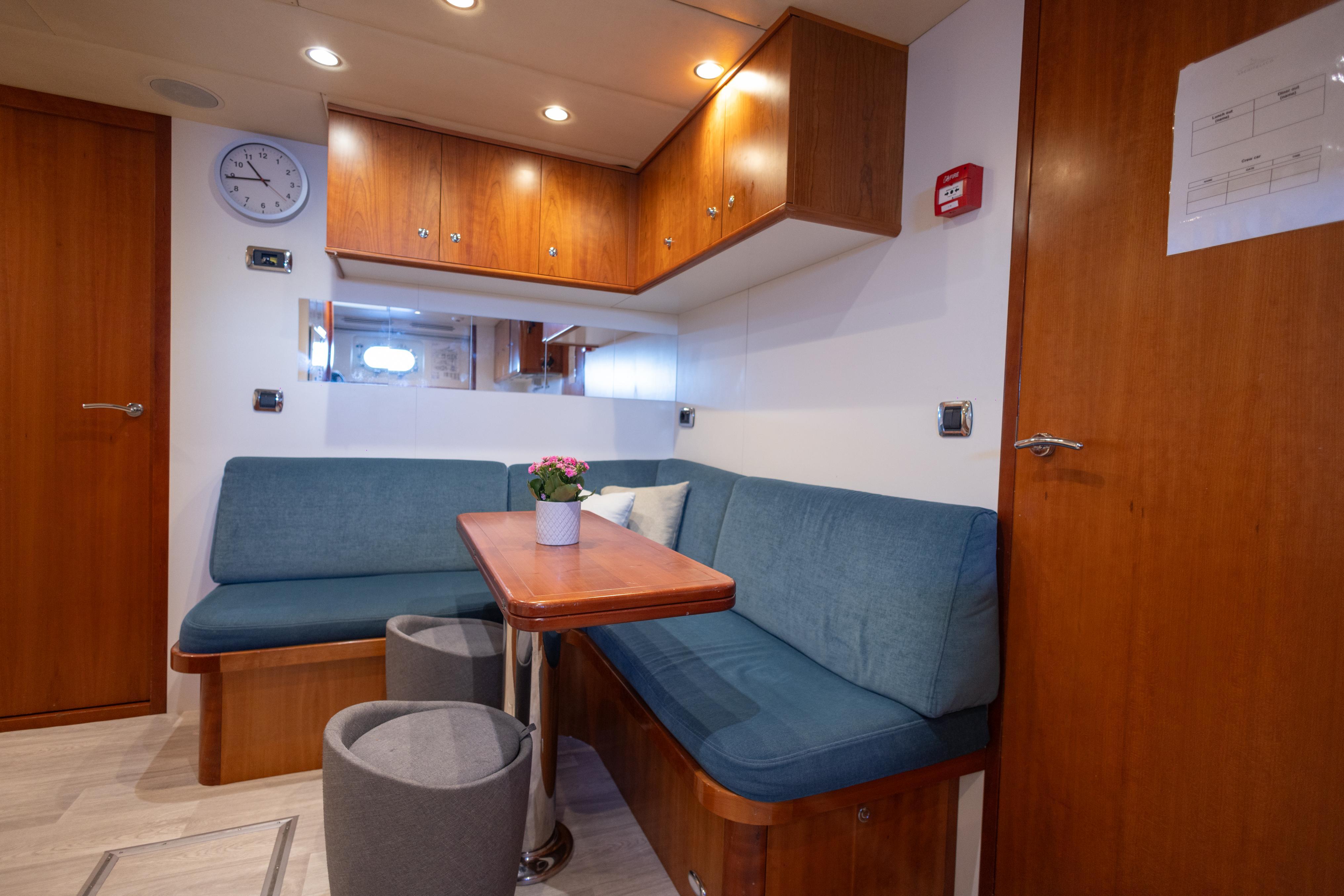 Cozy interior of 2005 Moonen Displacement Yacht with blue seating and wooden accents.