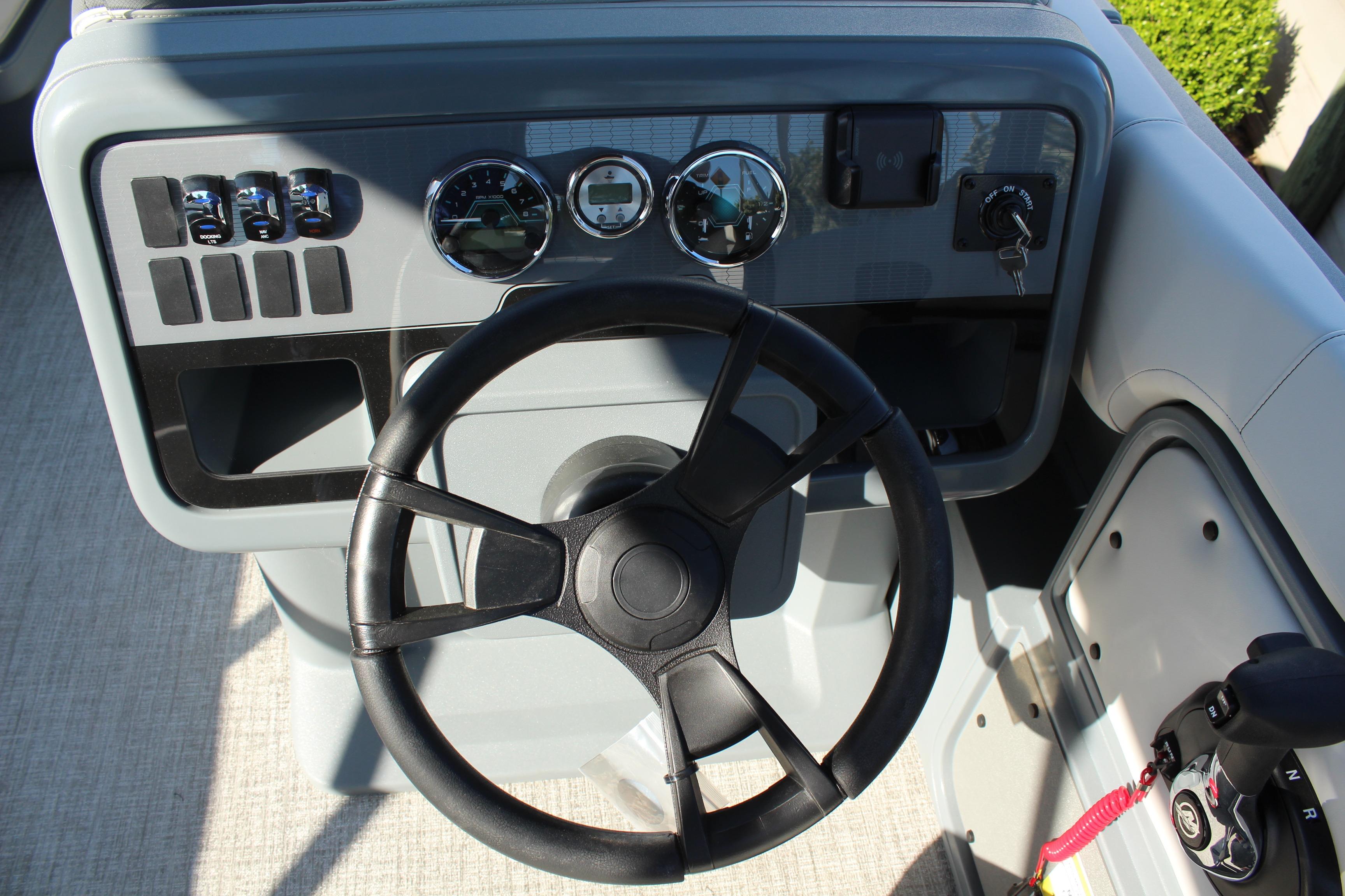 Steering console of 2026 Tahoe Pontoon Aura boat with gauges and controls.
