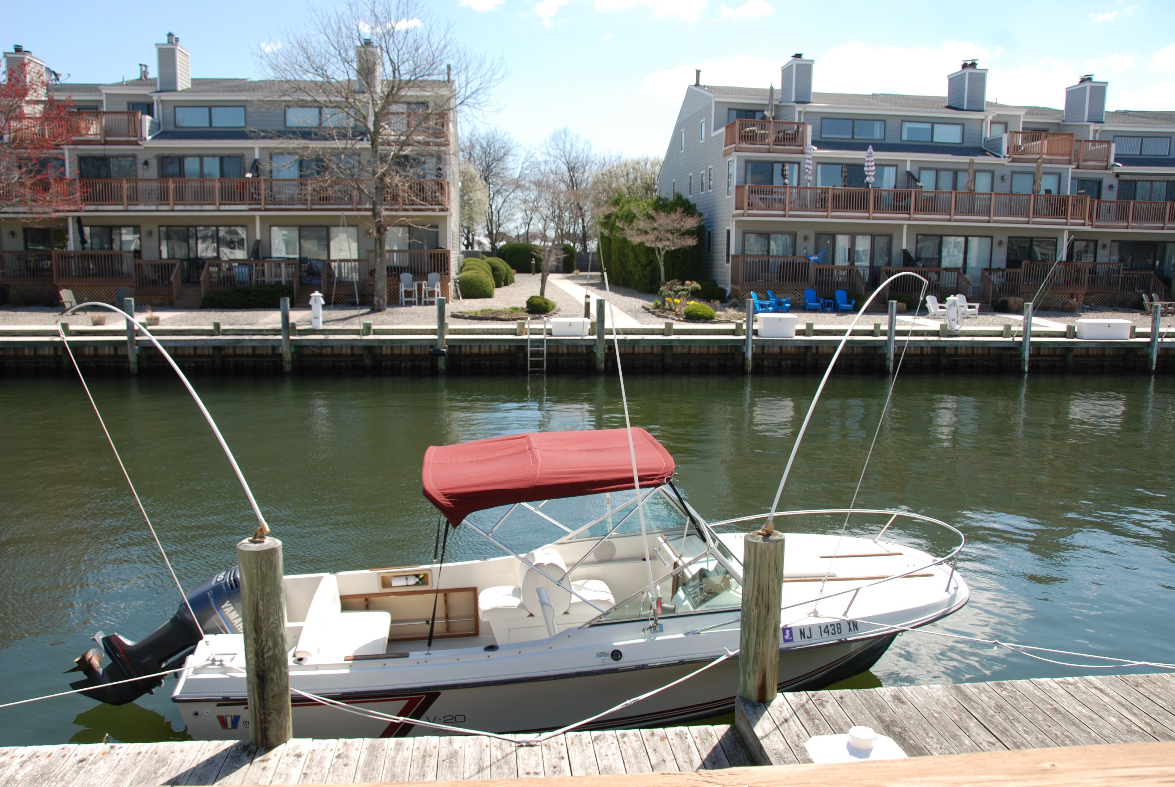 A 1987 Wellcraft V-20 Steplift docked in front of modern townhouses.