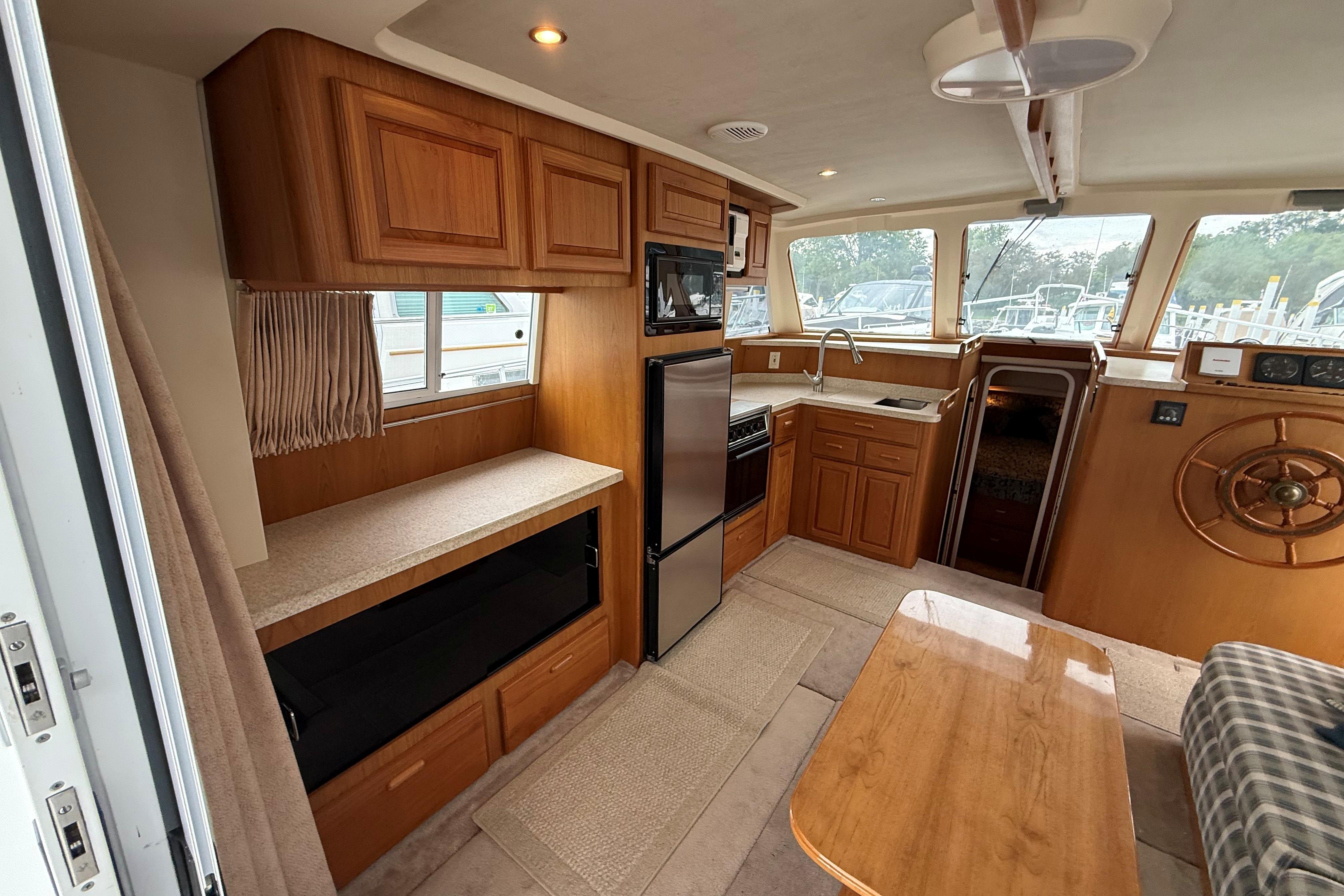 Interior of a 1999 Mainship 350 Trawler with wood cabinetry and modern appliances.