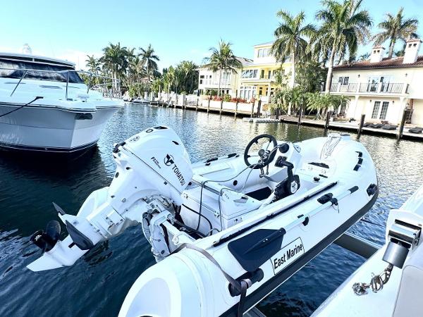 Aquila 44 yacht docked by waterfront homes, featuring a small motorboat.