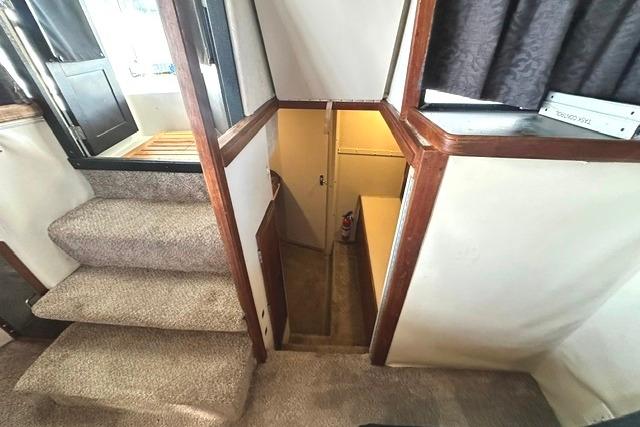 Interior view of 1989 Carver 32 Aft Cabin Motor Yacht with carpeted stairs and wood accents.