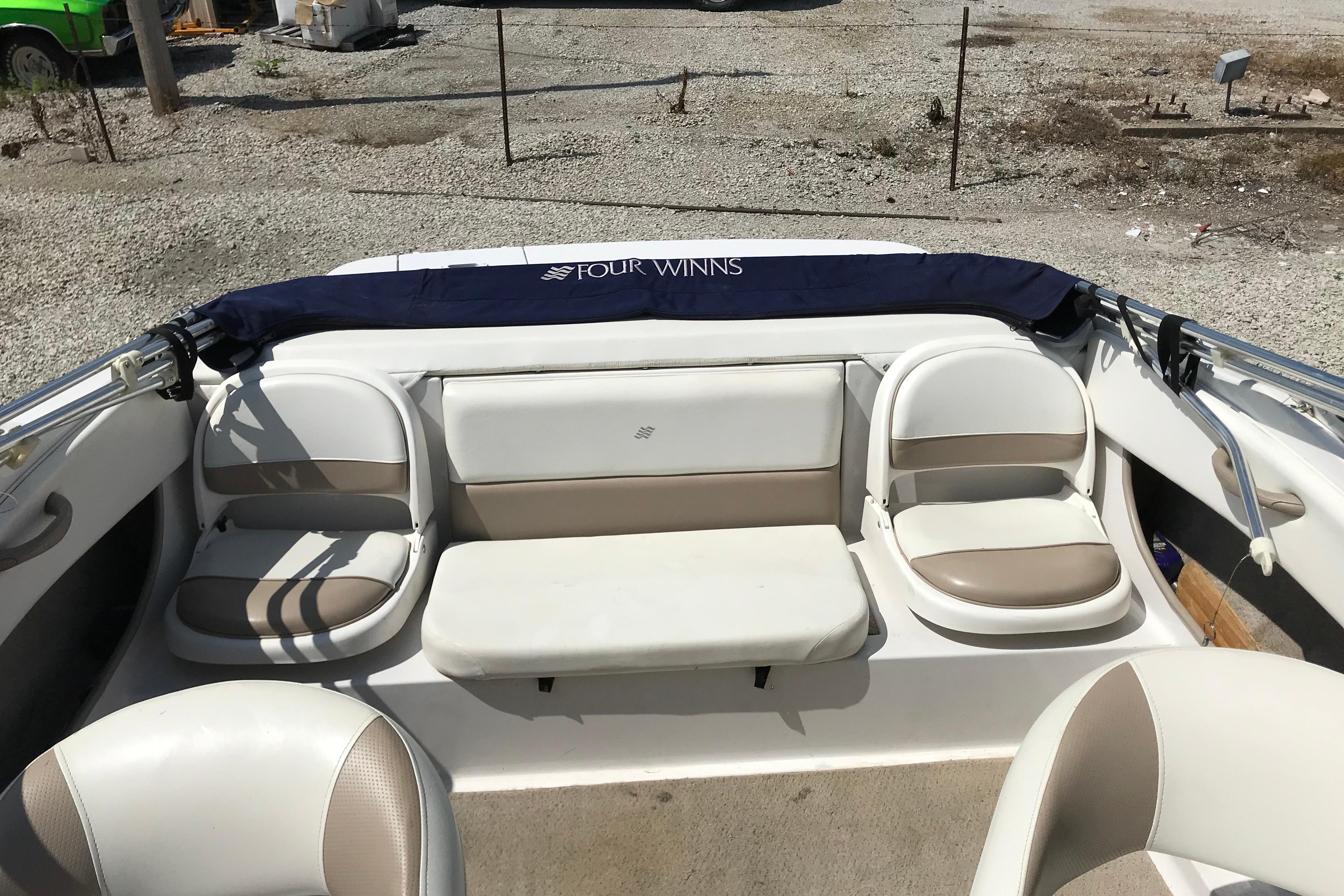 2005 Four Winns 180 Horizon FS boat interior with beige seating and blue cover.