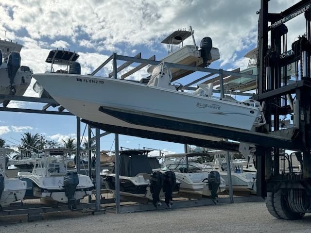 2021 Blue Wave 2200 PureBay boat on forklift in marina.
