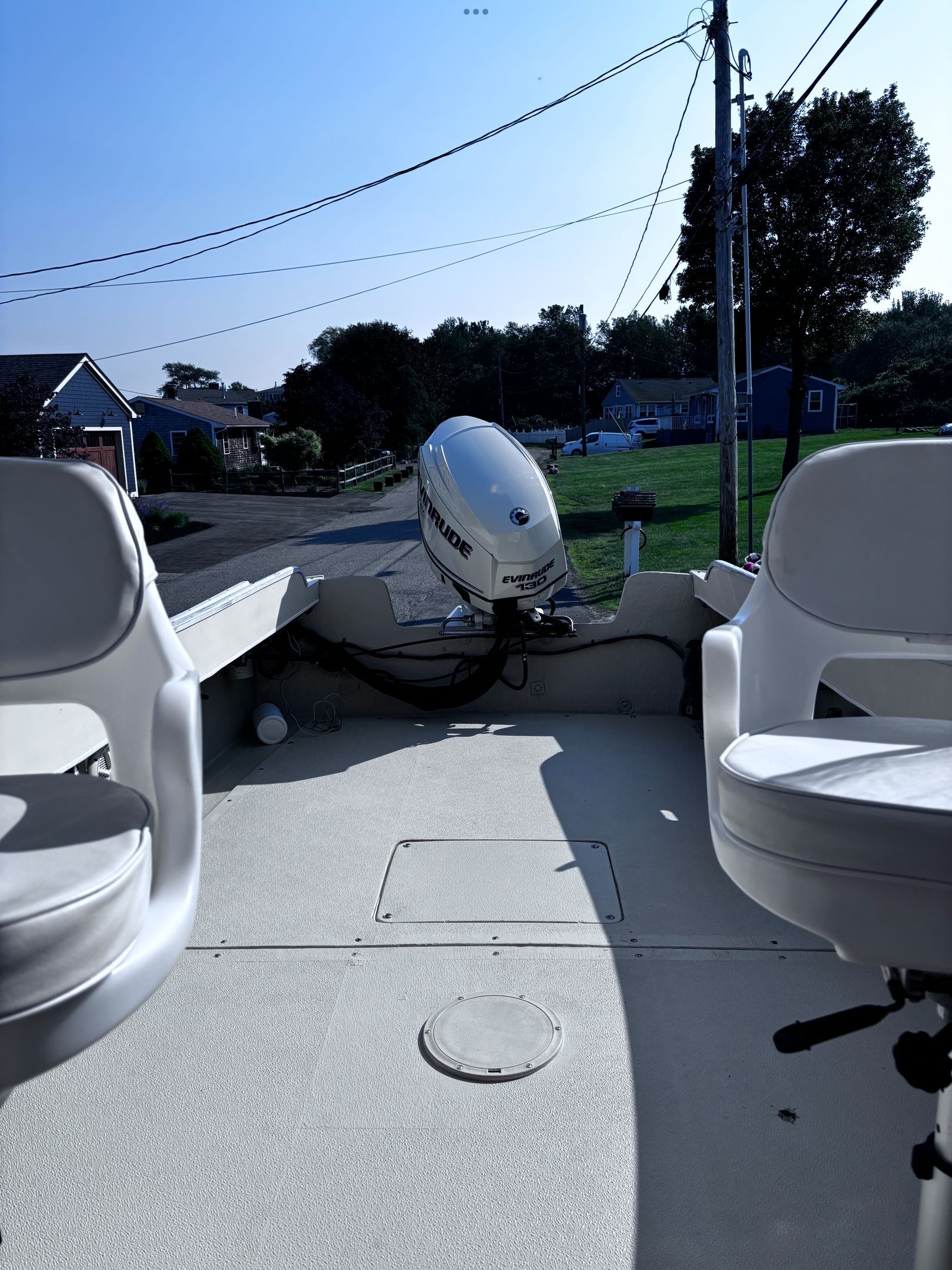 Interior view of a 1984 SISU 22’ Bass boat with two white seats and an outboard motor.