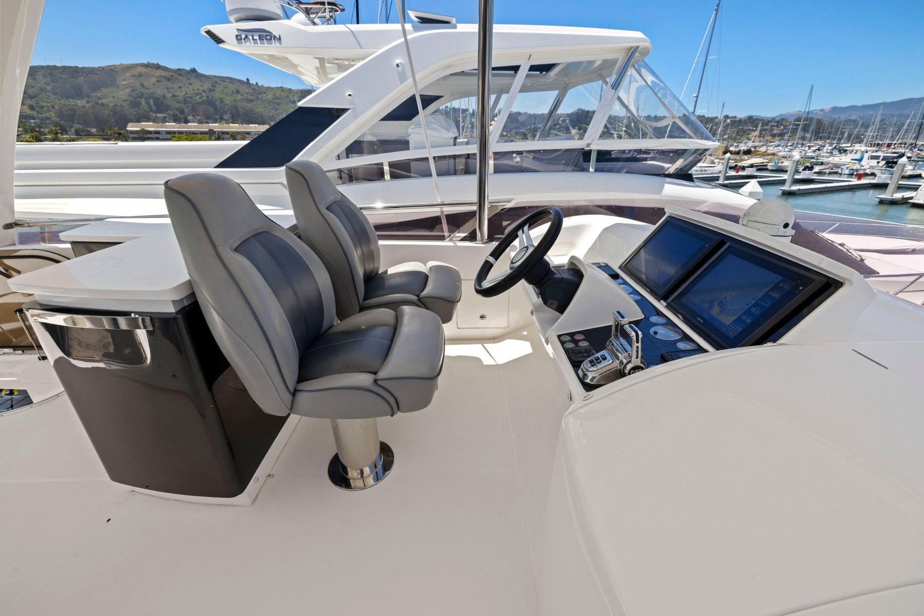 Flybridge helm of 2015 Princess 60 Motor Yacht with dual seats and navigation screens.