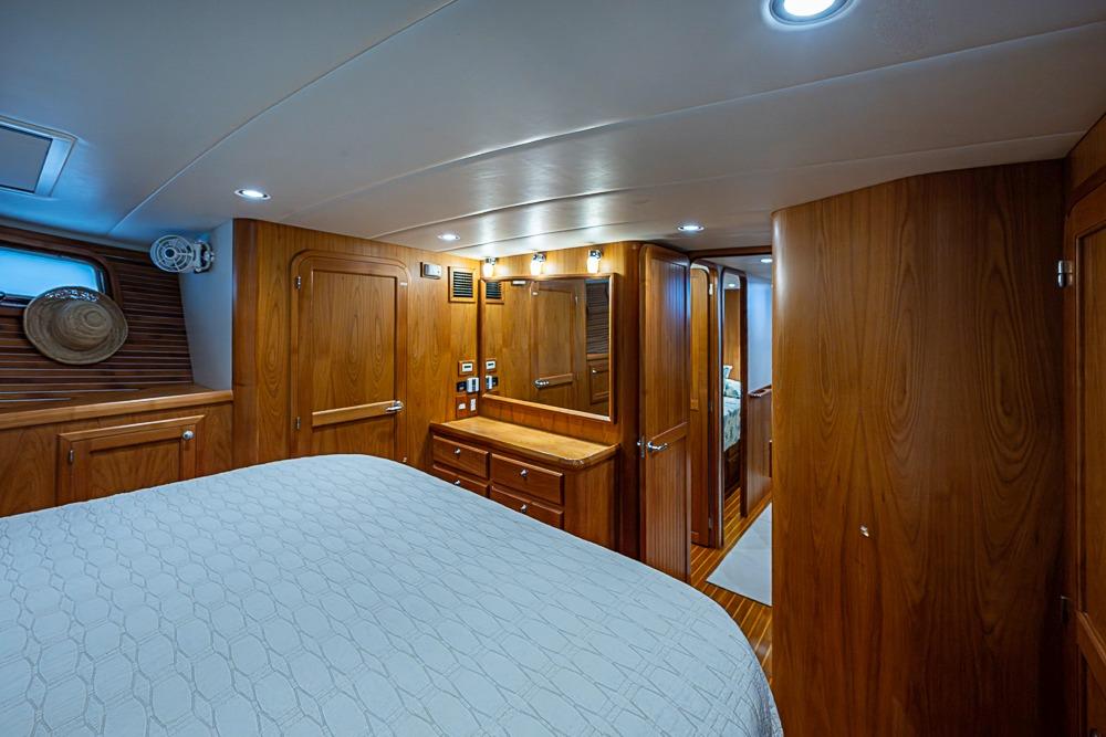 Luxurious 2016 Kadey-Krogen 52 yacht bedroom with elegant wood paneling and ambient lighting.
