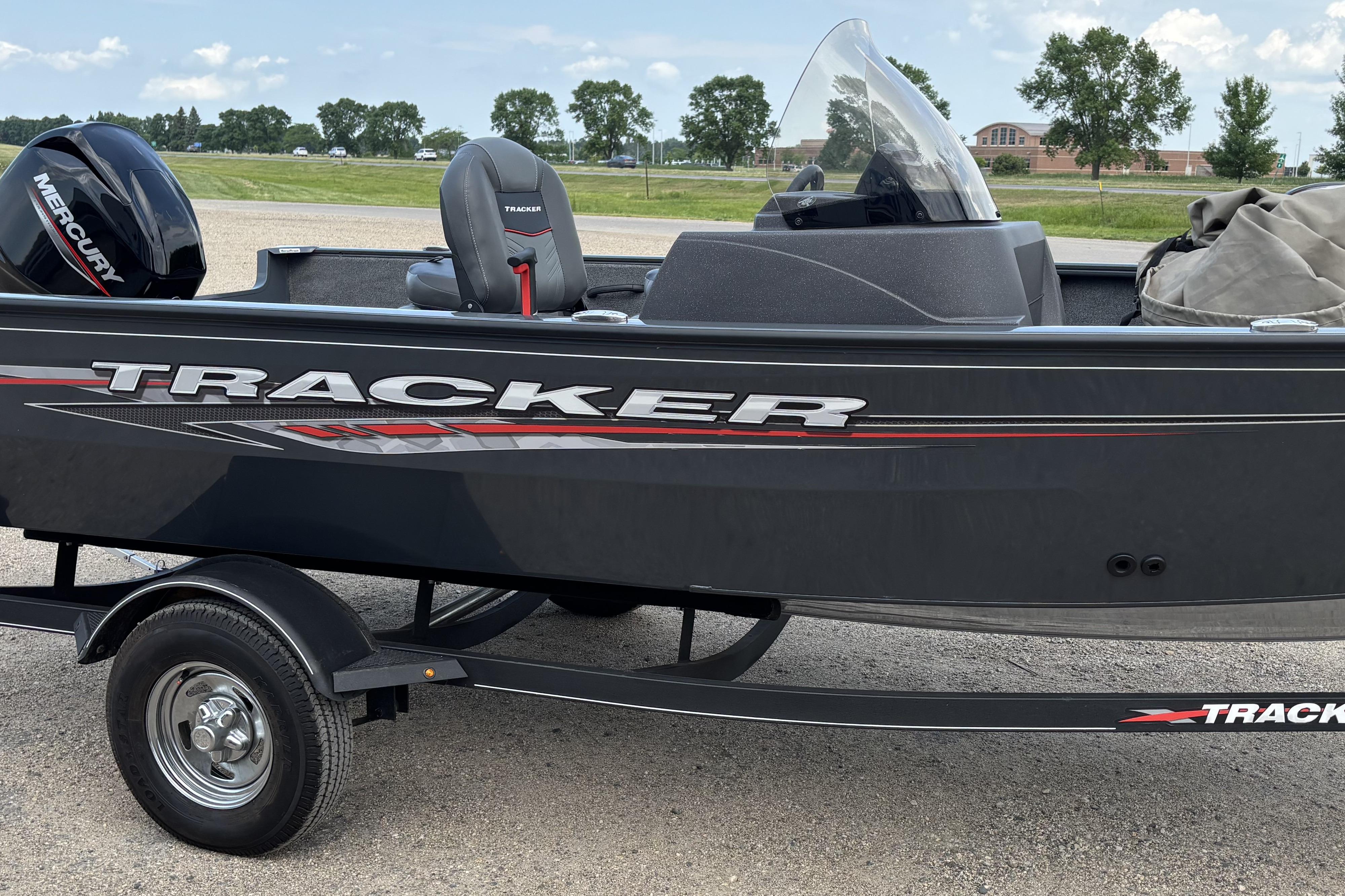 2021 Tracker Pro Guide V-16 WT boat with Mercury engine on trailer, parked outdoors.