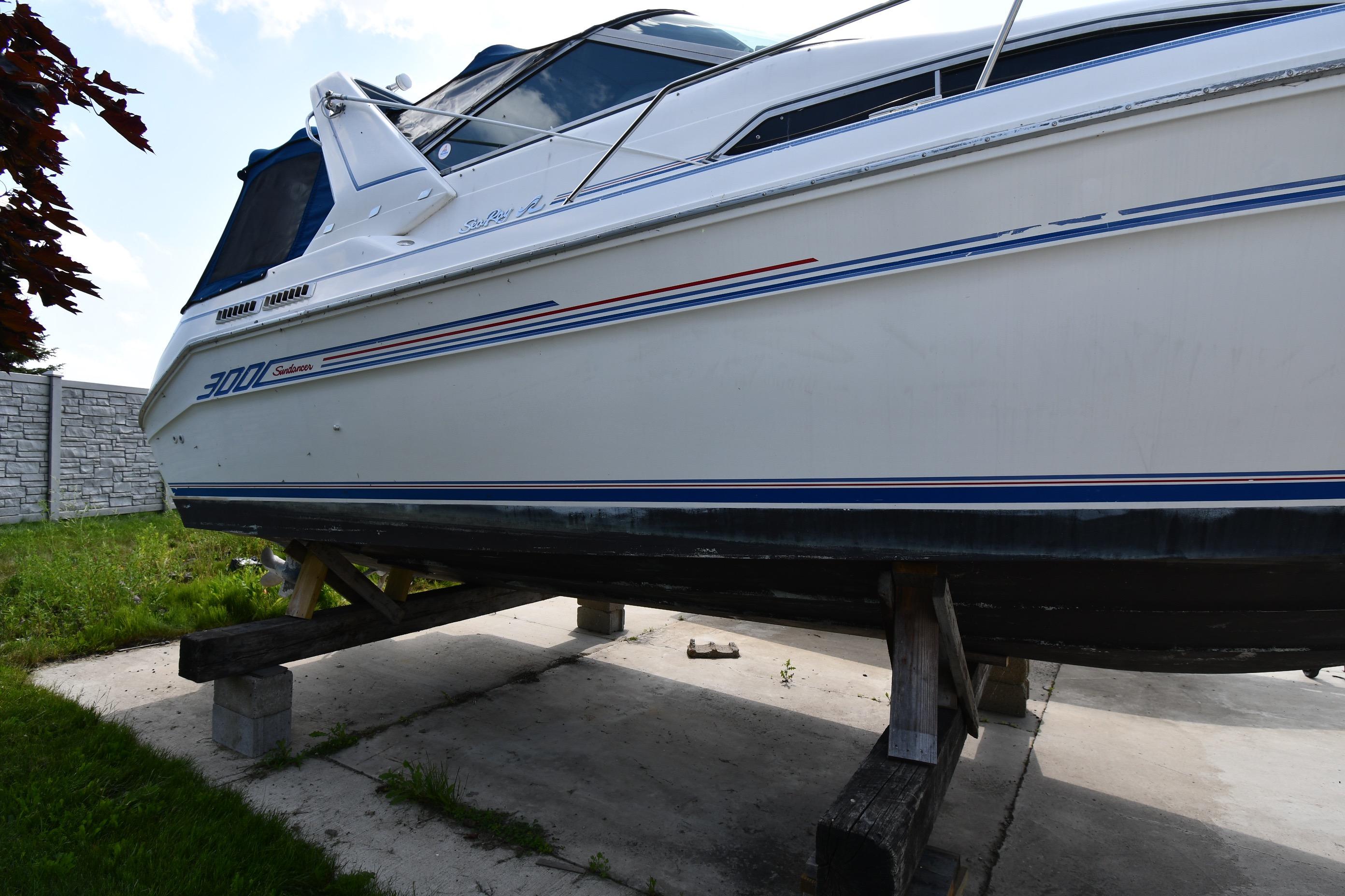1993 Sea Ray 300 Sundancer boat on wooden supports, side view.