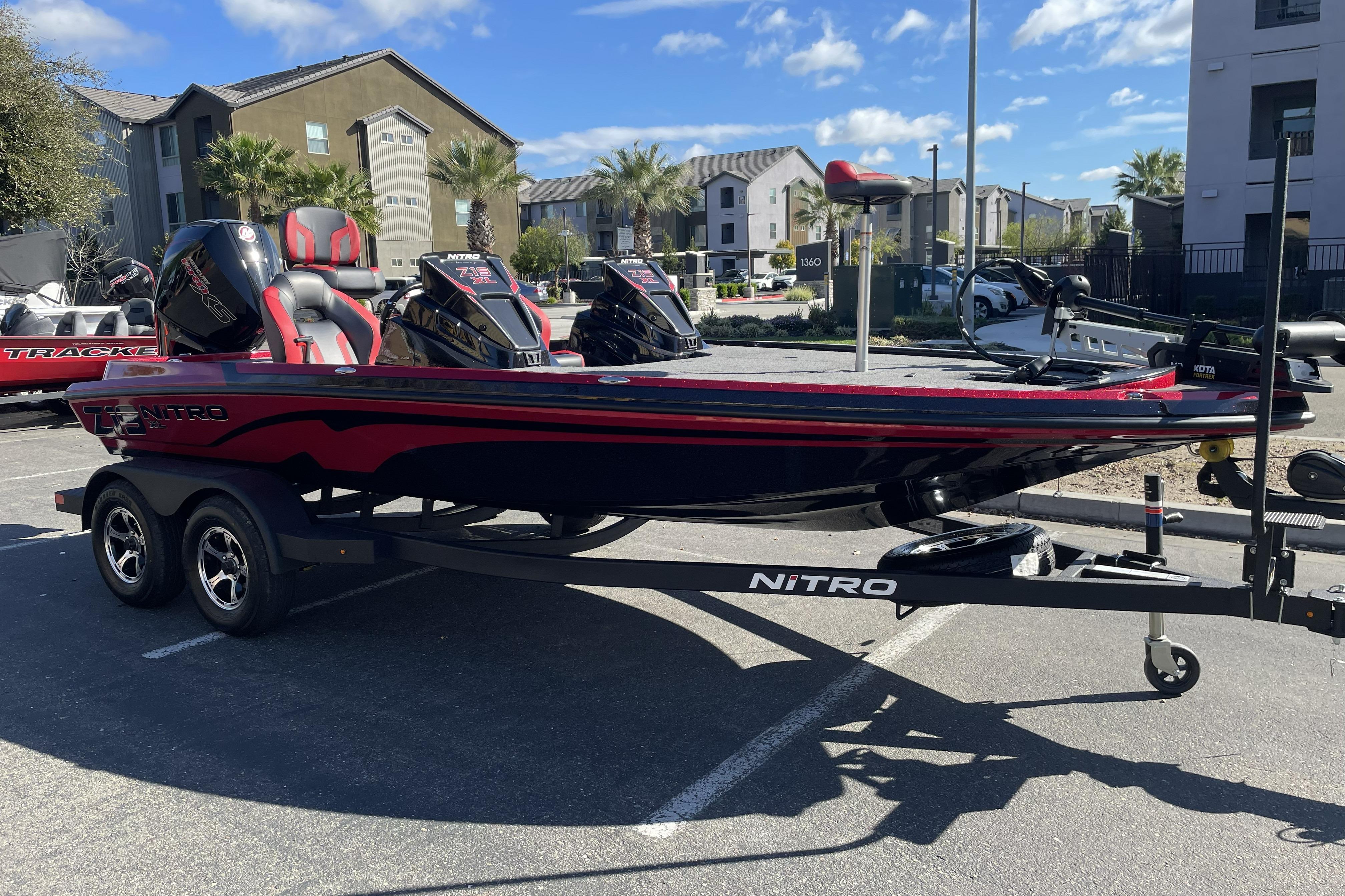 2026 Nitro Z19 XL boat in parking lot, red and black design, dual engines.