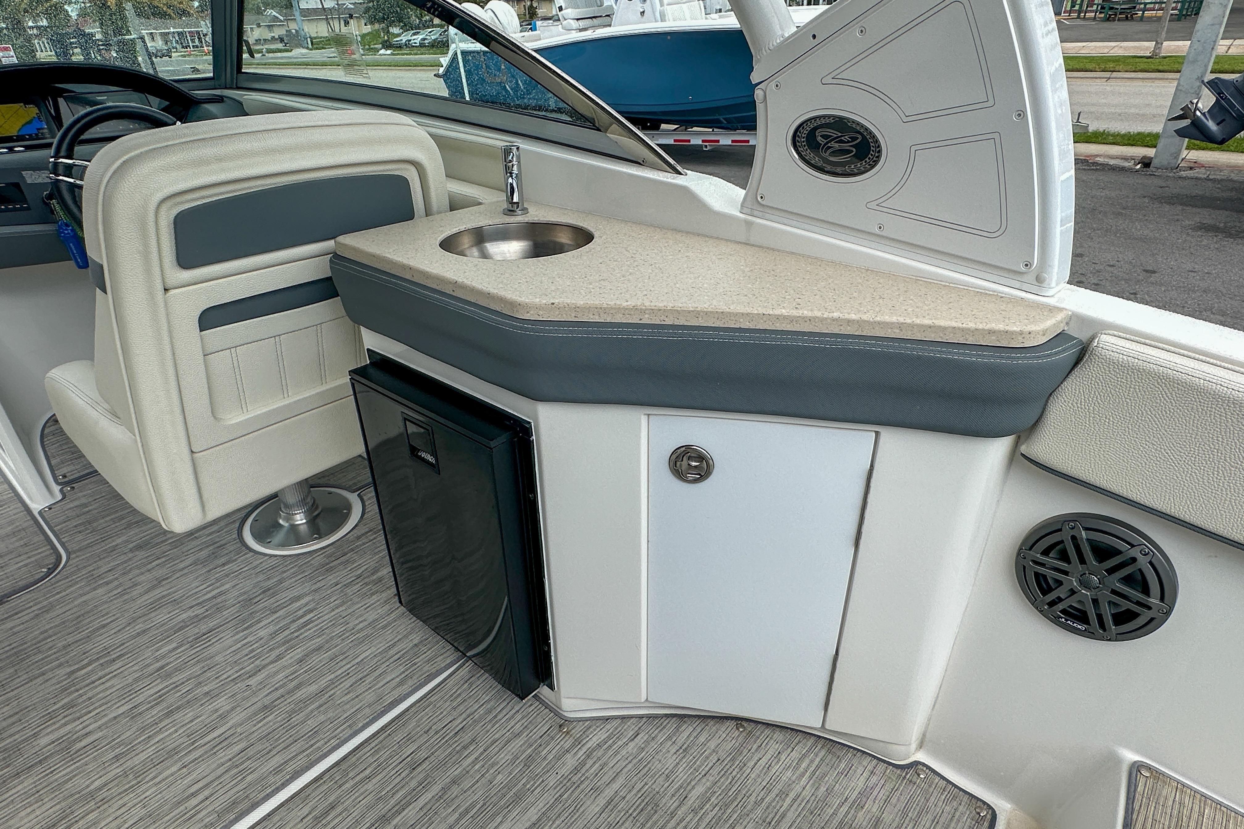 2022 Cobalt 25SC boat interior with sink, mini fridge, and seating area.