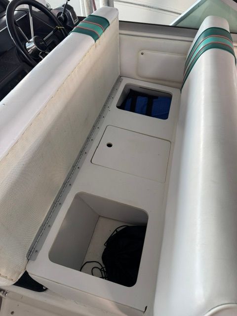 Interior of a 1992 Sea Ray 290 Sundancer with white upholstery and storage compartments.