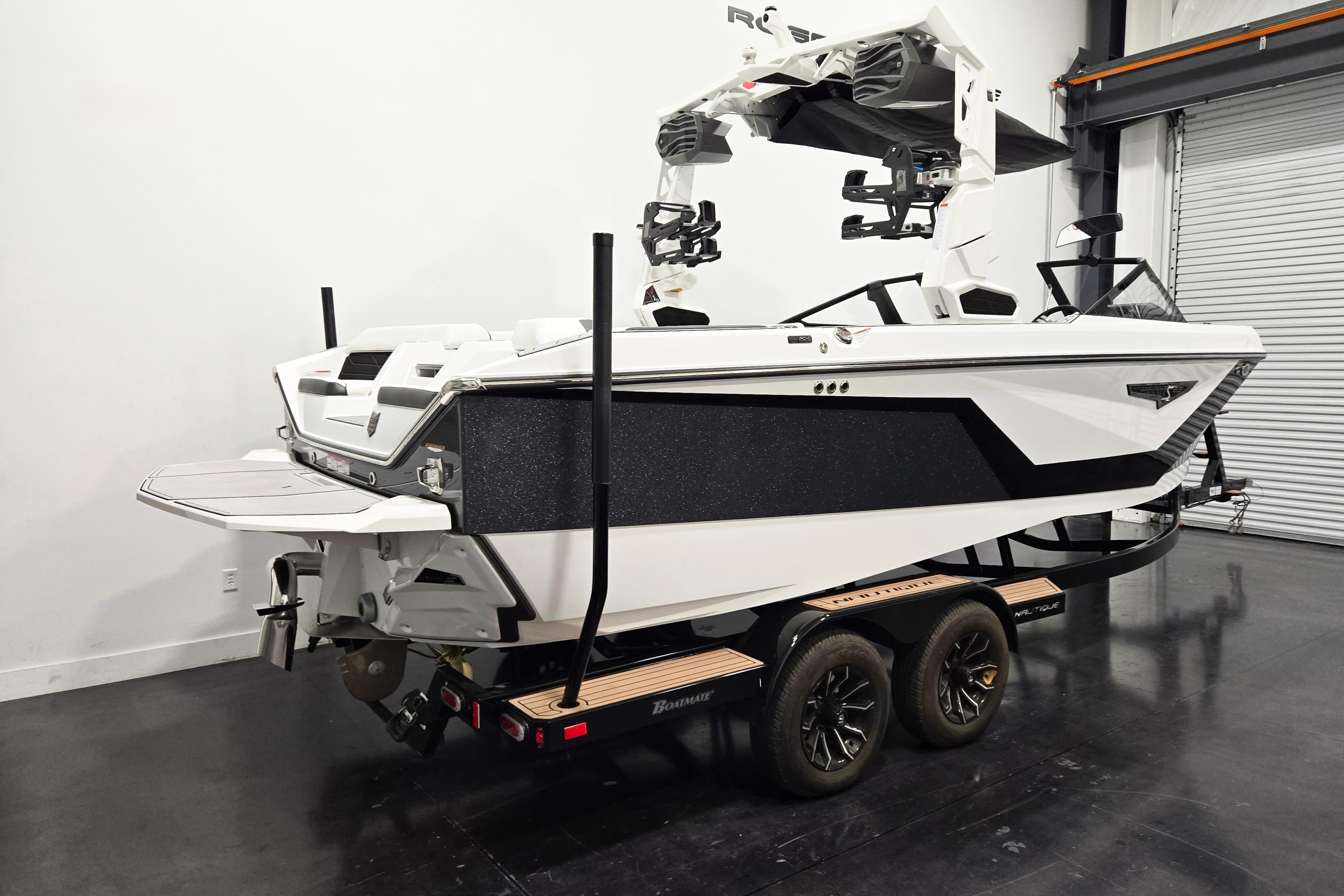 2026 Nautique Super Air Nautique S23 boat on trailer in showroom.
