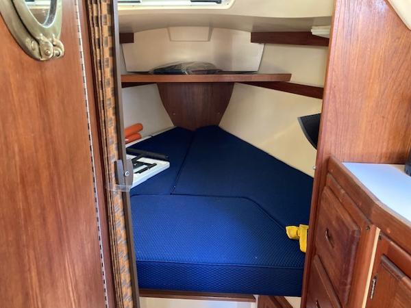 1989 Catalina 30 sailboat interior with blue cushions and wooden cabinetry.