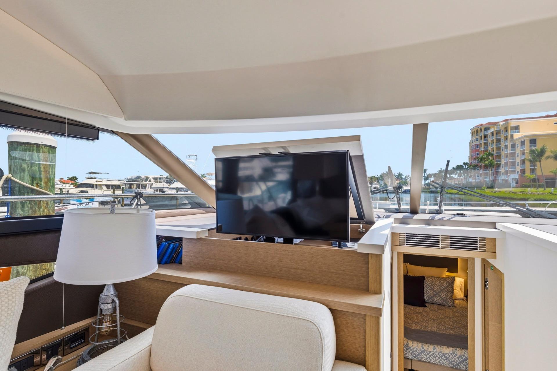 Interior of 2022 Prestige 520 yacht with TV, lamp, and cozy cabin view.