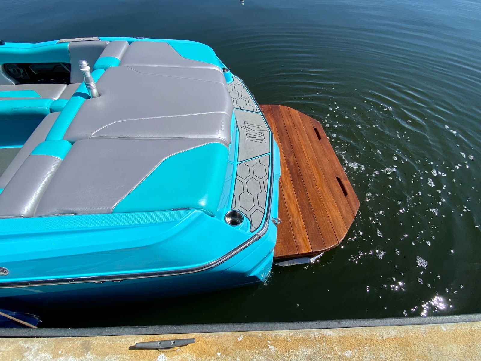 Rear view of a 2021 MasterCraft NXT22 boat by the water.