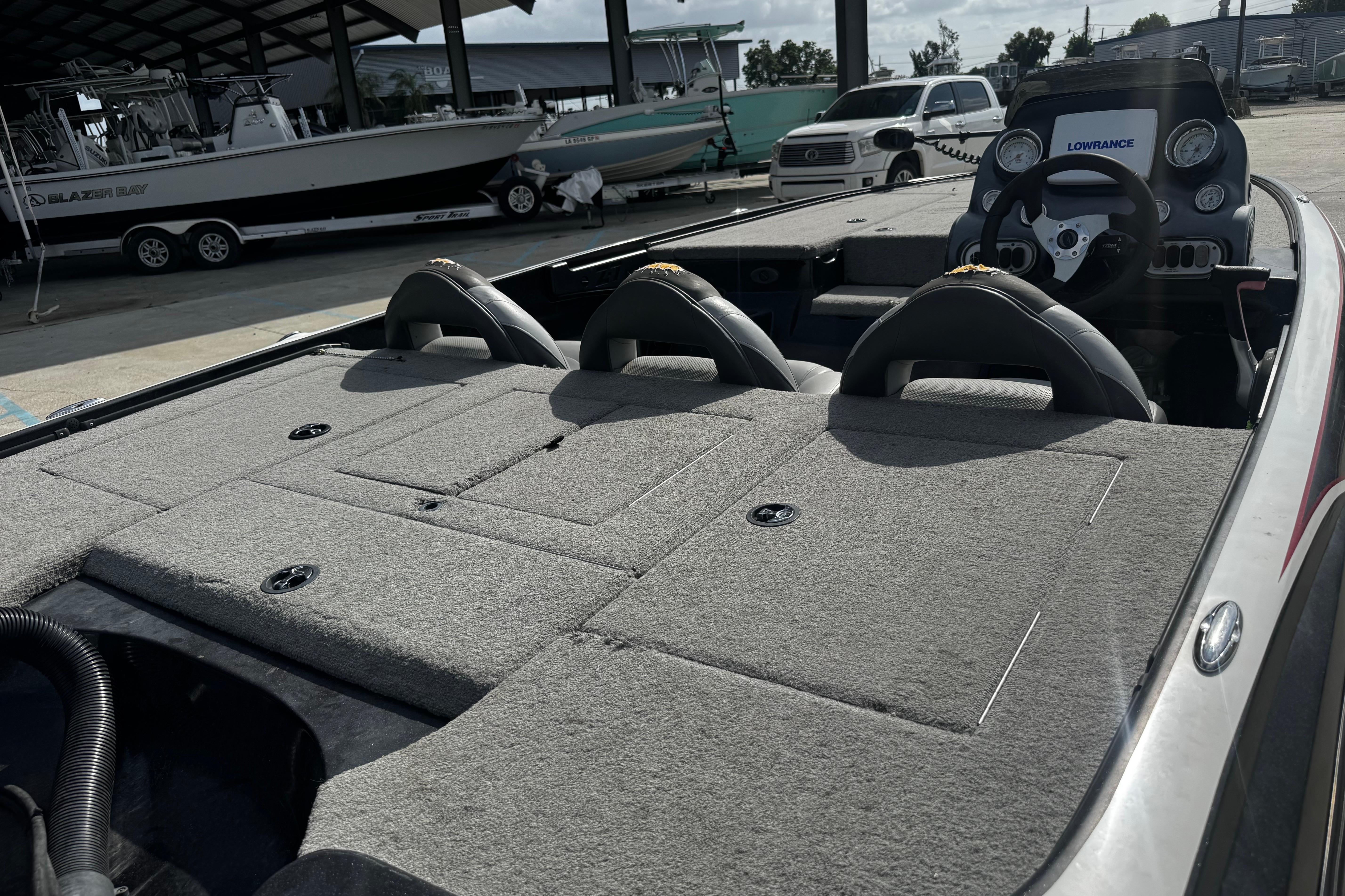 2012 Nitro Z-7 boat interior with steering wheel and seating, parked near other boats.