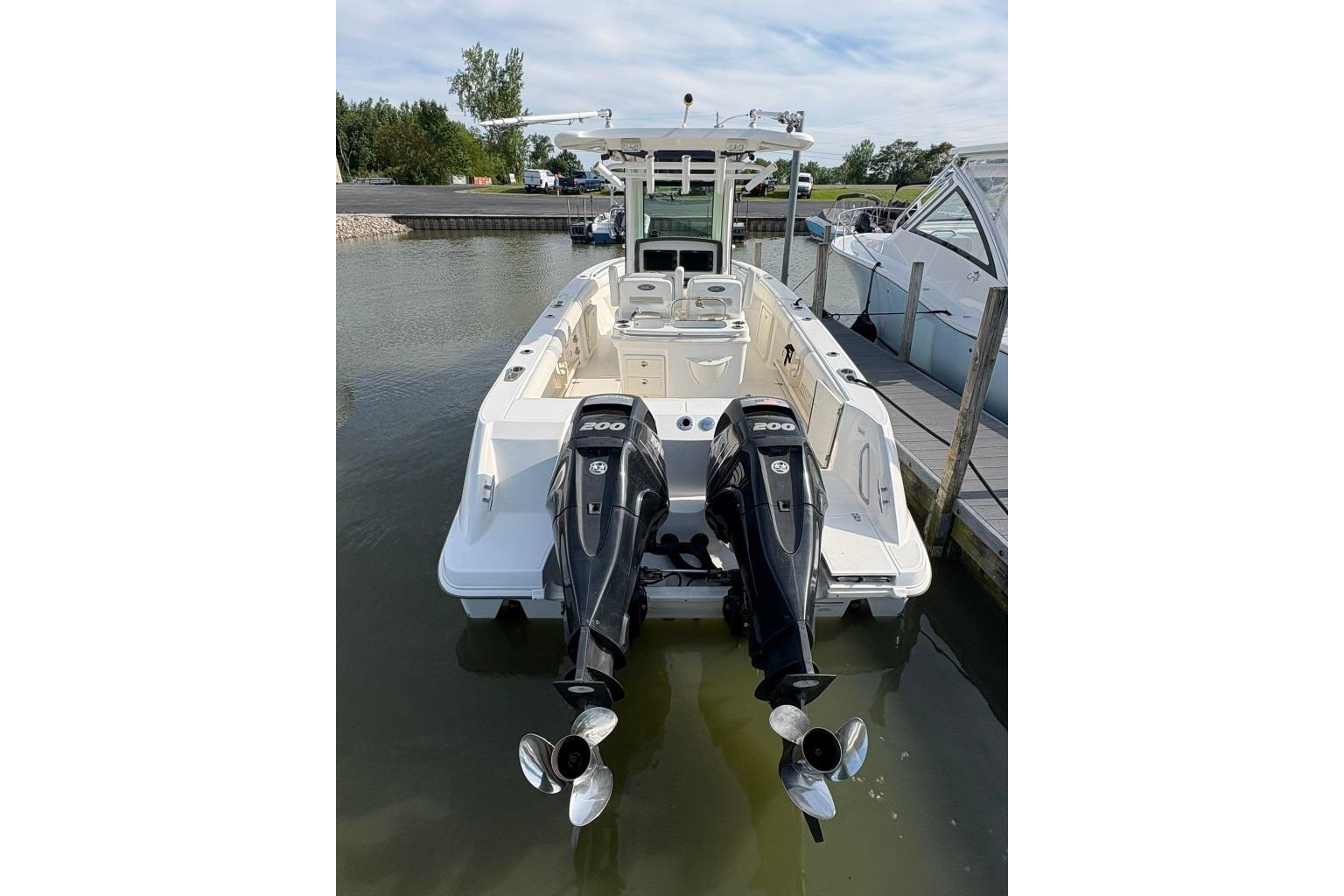 2012 Boston Whaler 250 Outrage boat with dual 200 HP engines docked at marina.