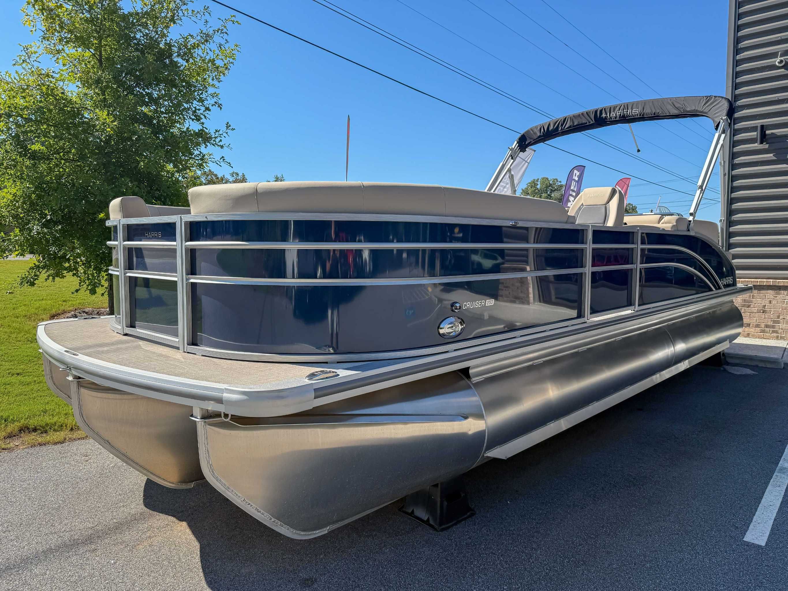 2025 Harris Cruiser 250 CWDH pontoon boat on parking lot.