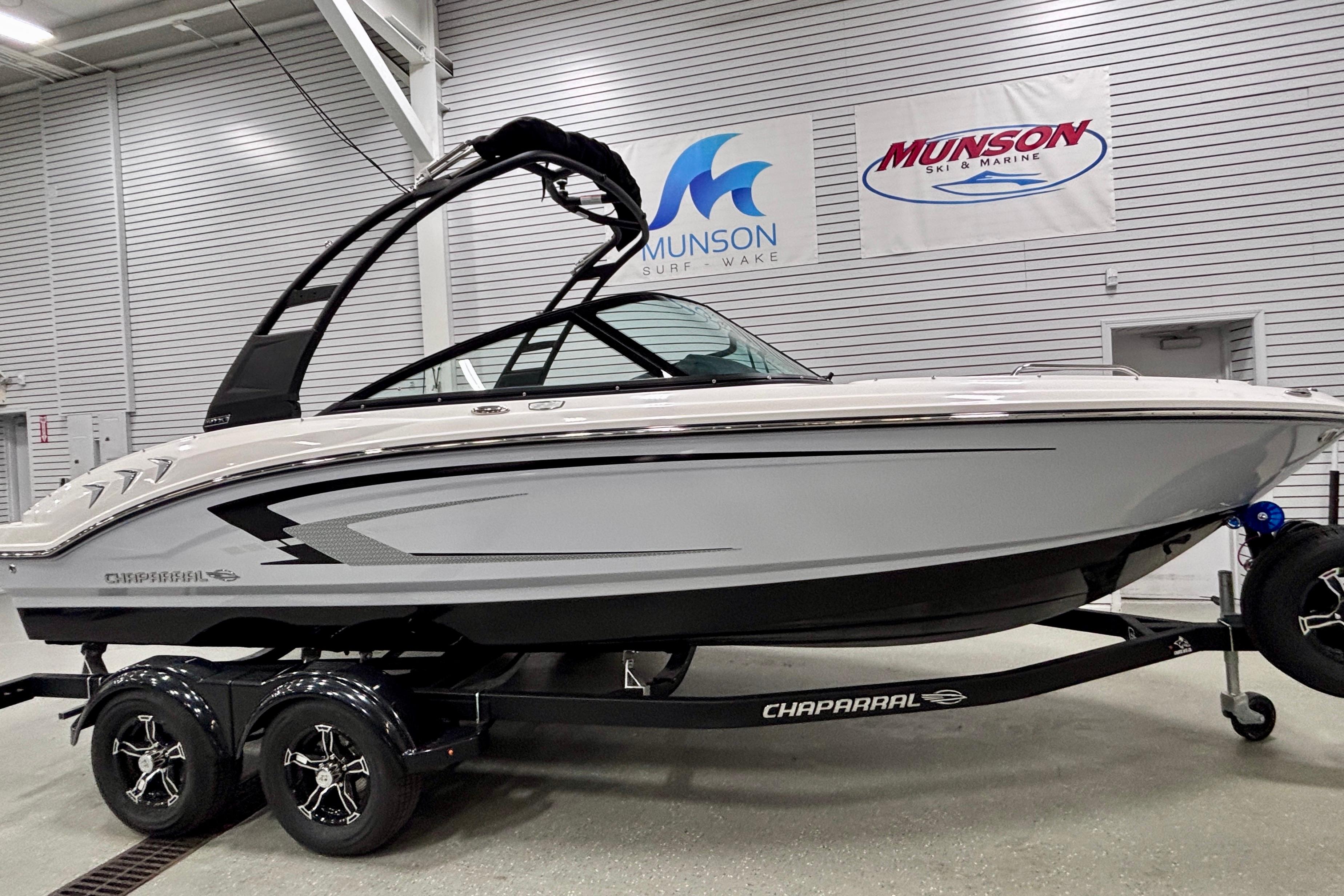 2026 Chaparral 21 SSi boat on trailer in showroom, Munson Surf & Wake signage.