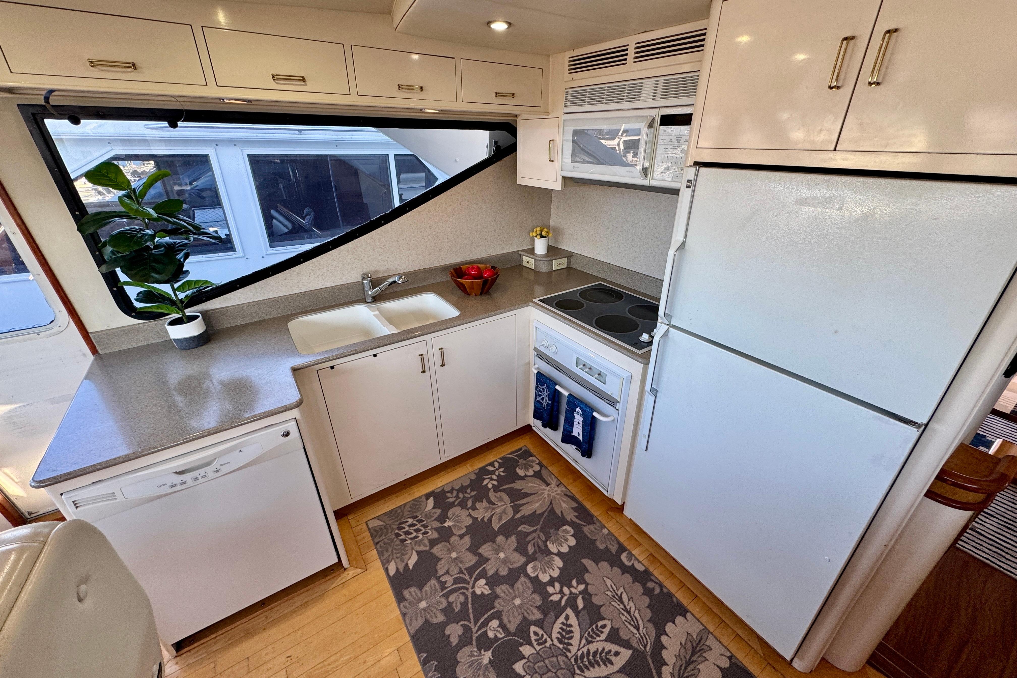 Modern kitchen in 1995 Queenship 62 Pilothouse Motor Yacht with appliances and large window.