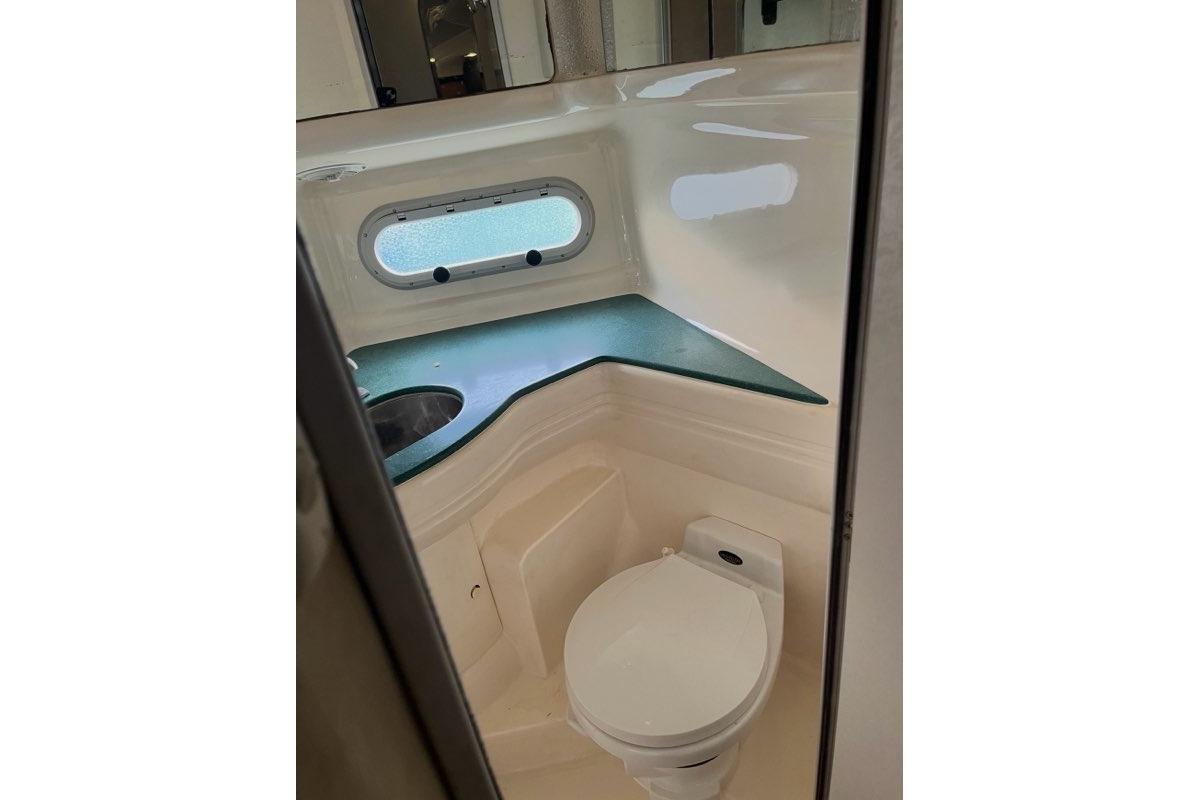 Bathroom interior of 1999 Sealine F44 yacht, featuring toilet and sink with window.